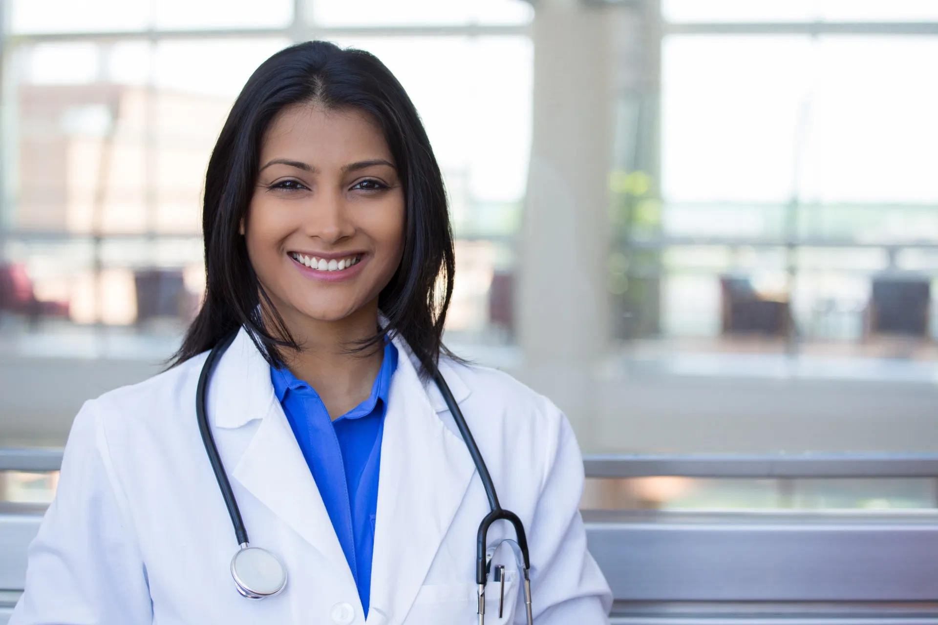 Uma médica examinando um paciente com um estetoscópio, mostrando cuidado e atenção.