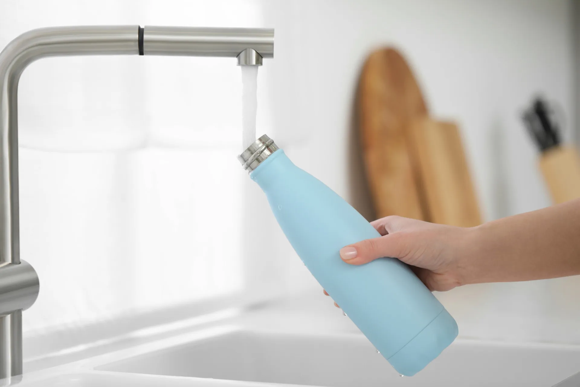 Pessoa bebendo um copo de água fresca com uma expressão de satisfação.