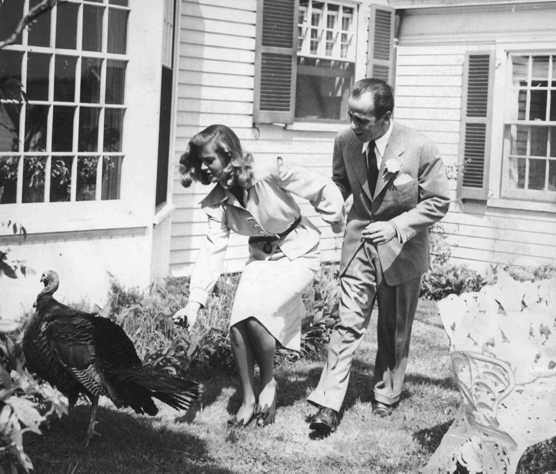 Humphrey Bogart e Lauren Bacall em uma fazenda em Ohio, com um peru ao lado, durante a celebração de seu casamento em 1945.