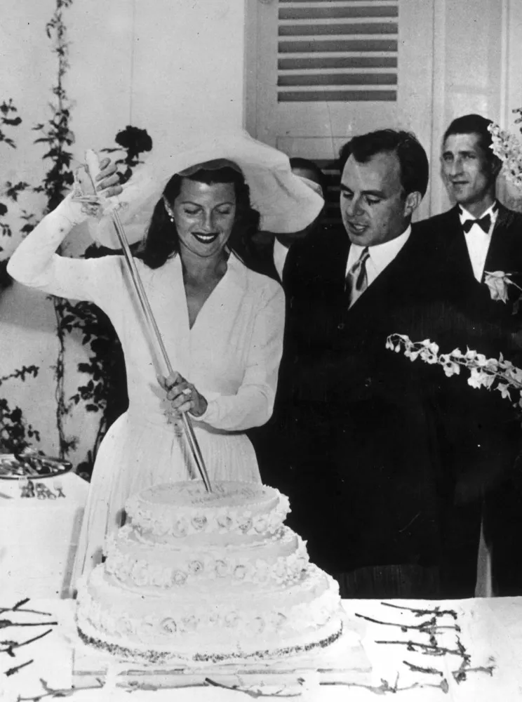 Rita Hayworth e o Príncipe Aly Khan cortando o bolo de casamento.