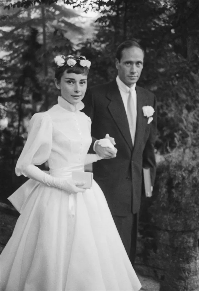 Audrey Hepburn usando seu famoso vestido de noiva de gola alta no casamento com Mel Ferrer em 1954.