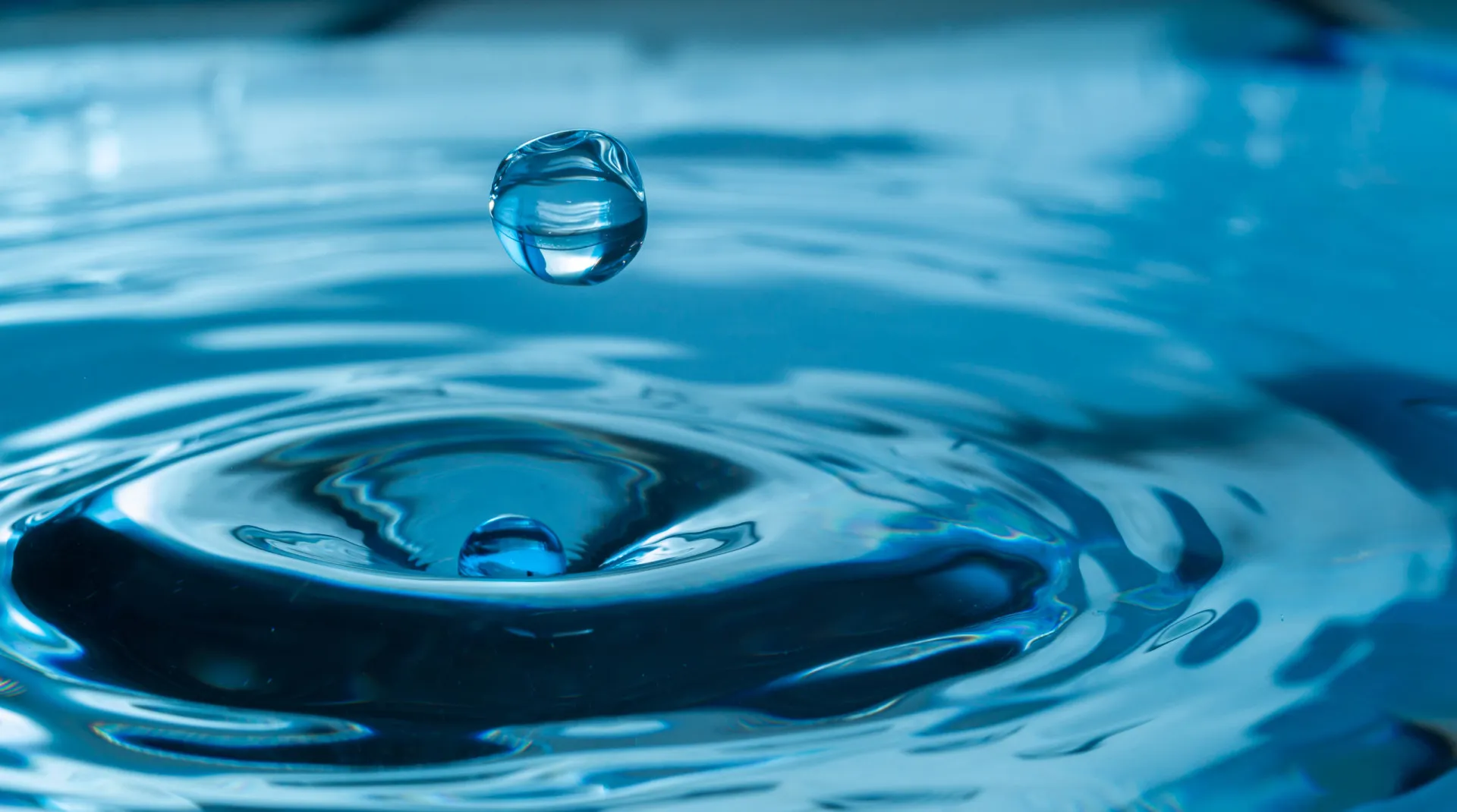Símbolos dos signos de água: Câncer, Escorpião e Peixes, em um fundo aquático azul.