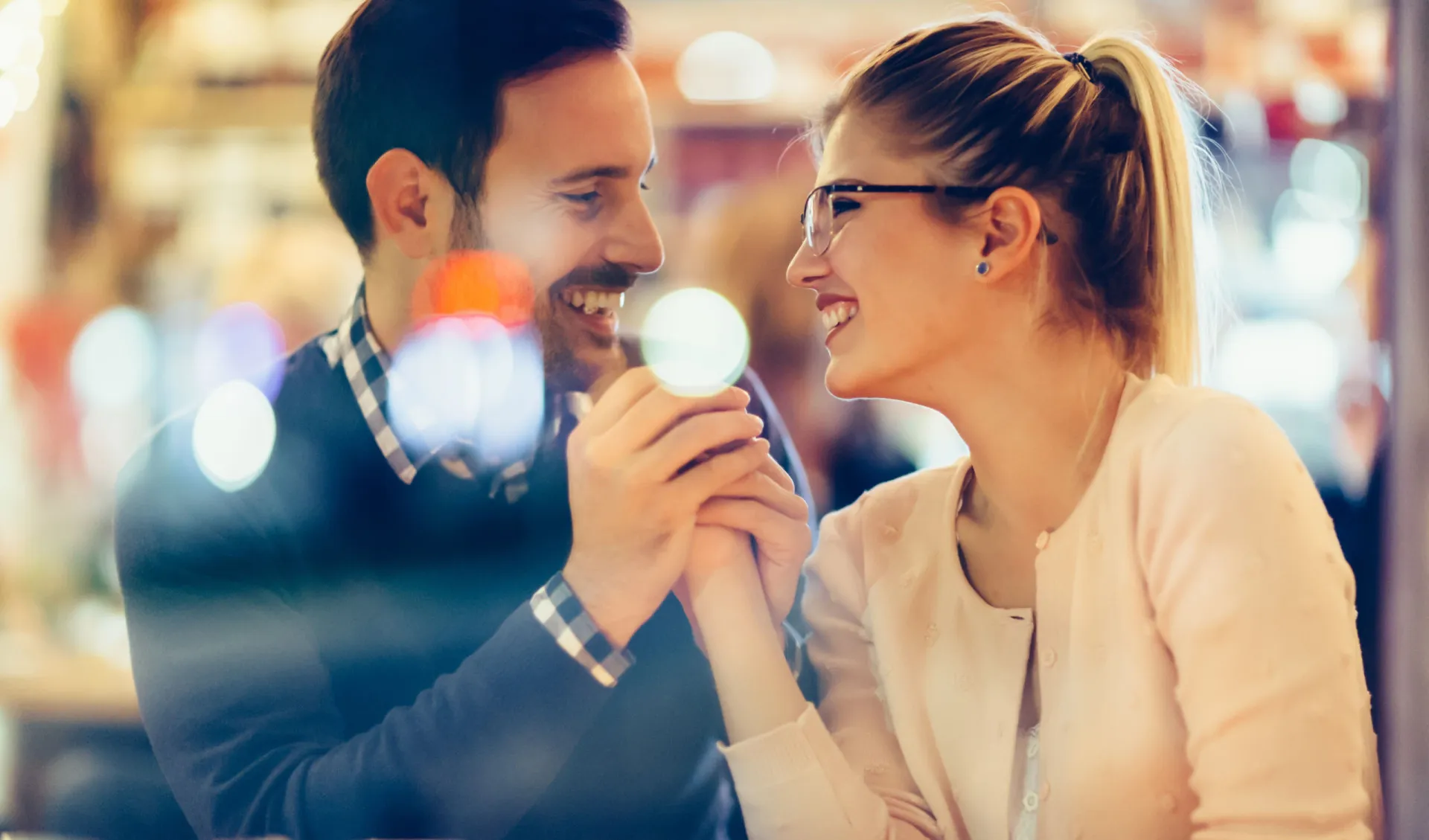 Um casal conversando animadamente em um café, compartilhando um momento de conexão.