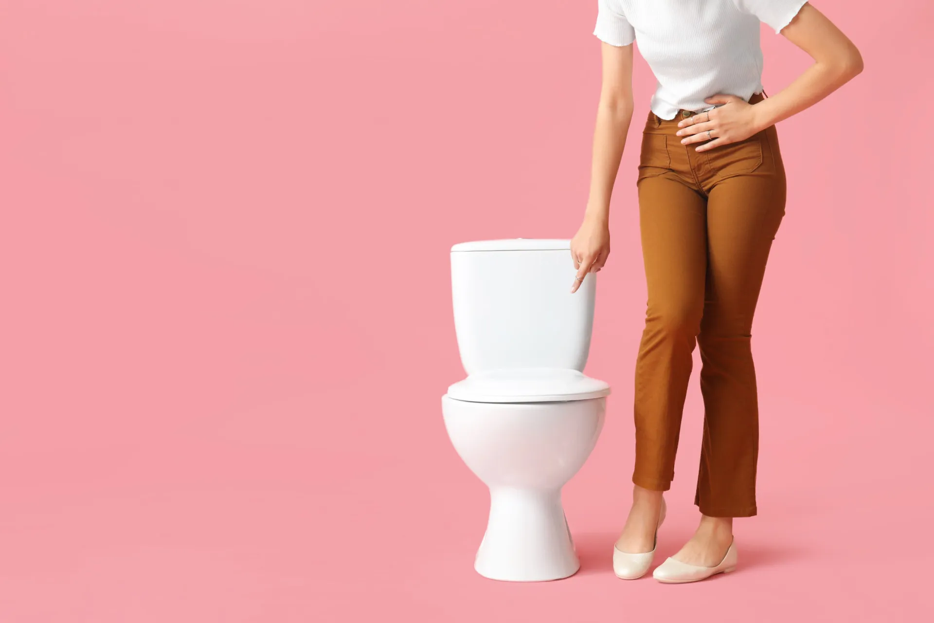 Pessoa sentada no vaso sanitário durante o dia, ilustrando a micção frequente.
