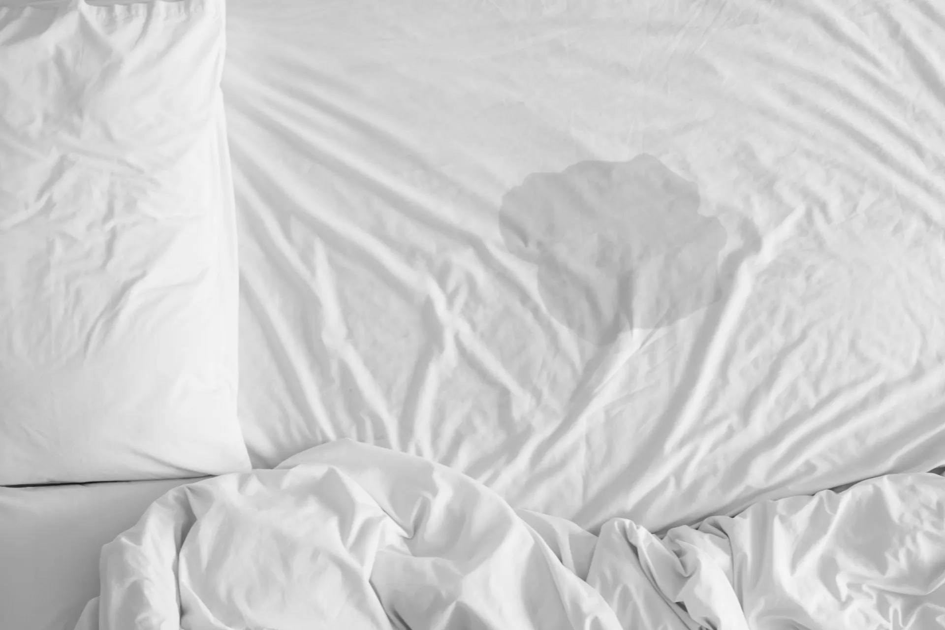 Lençol molhado, simbolizando a enurese noturna ou o ato de fazer xixi na cama.