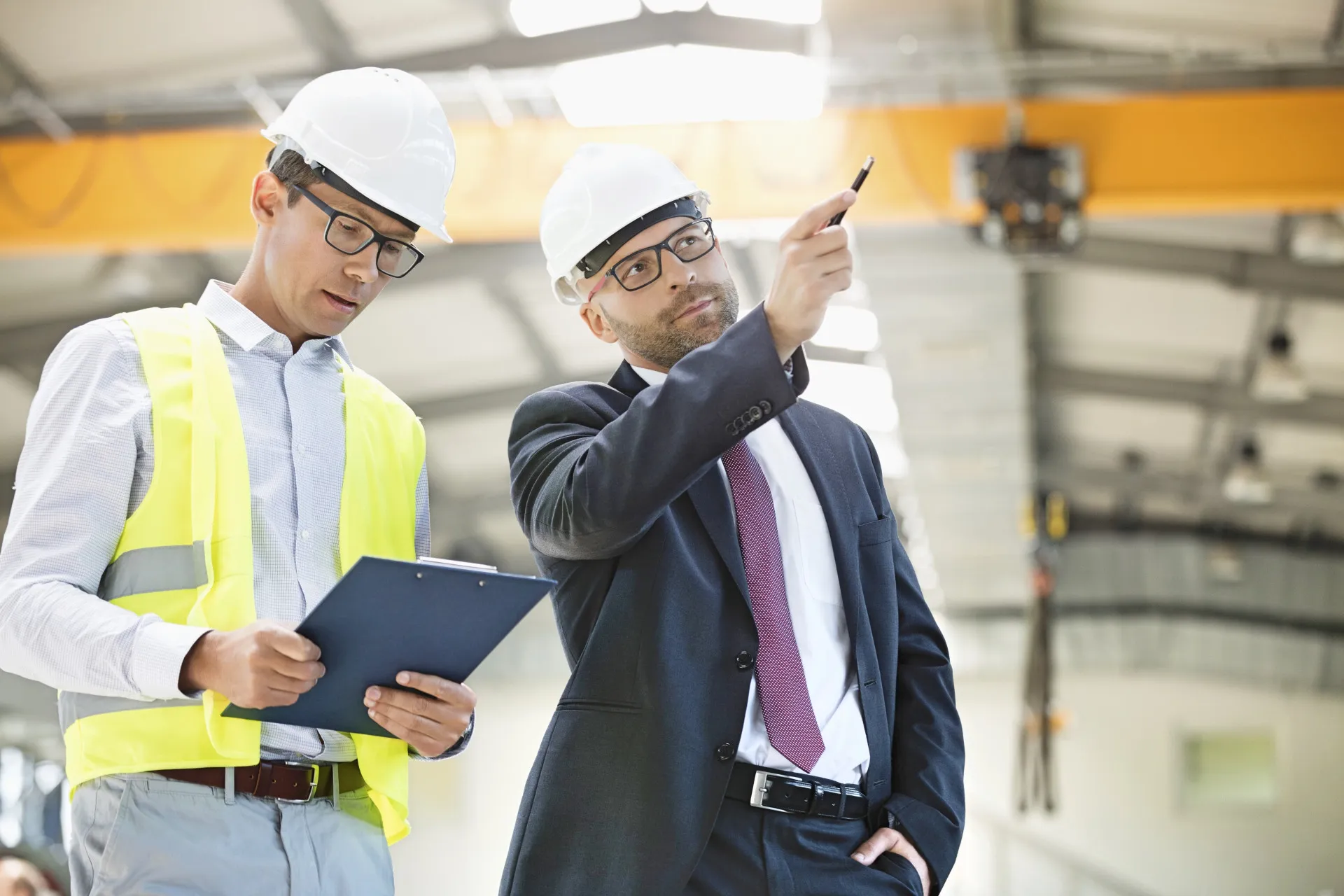 Profissional da construção civil inspecionando a fundação de uma casa.