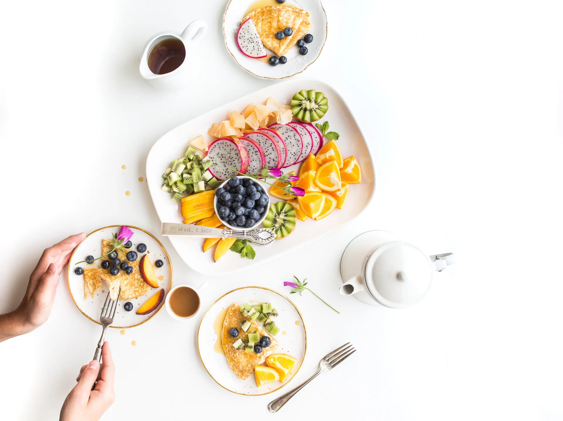 Prato com crepes finos dobrados e cobertos com frutas vermelhas frescas.