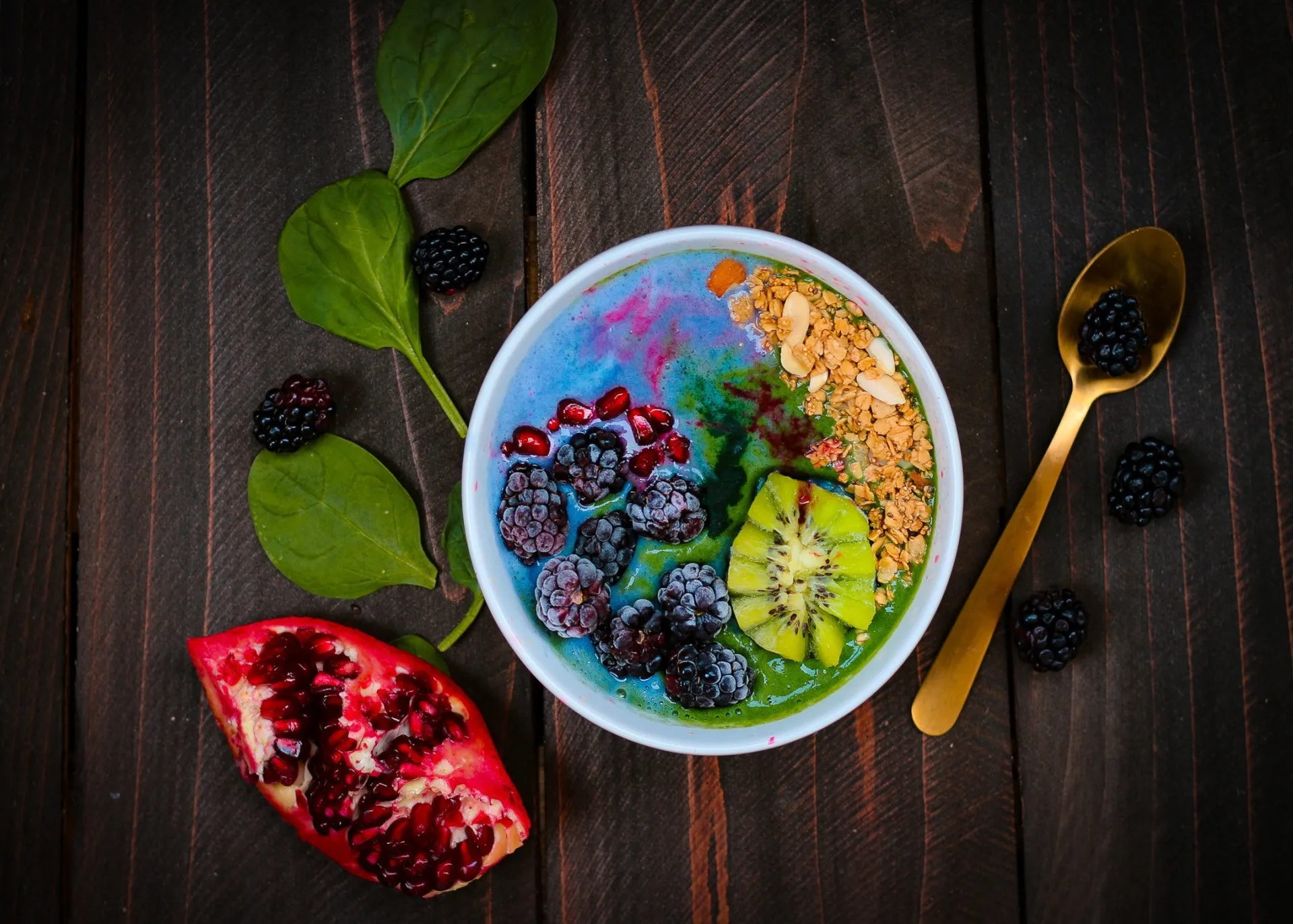 Tigela de smoothie roxo vibrante, decorada com frutas fatiadas, sementes e coco.
