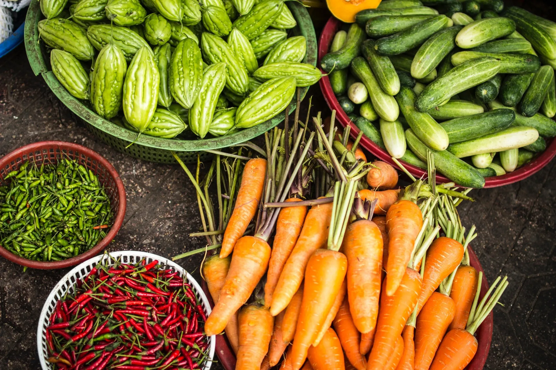 Mini legumes, como cenouras e rabanetes, recém-colhidos e com terra.