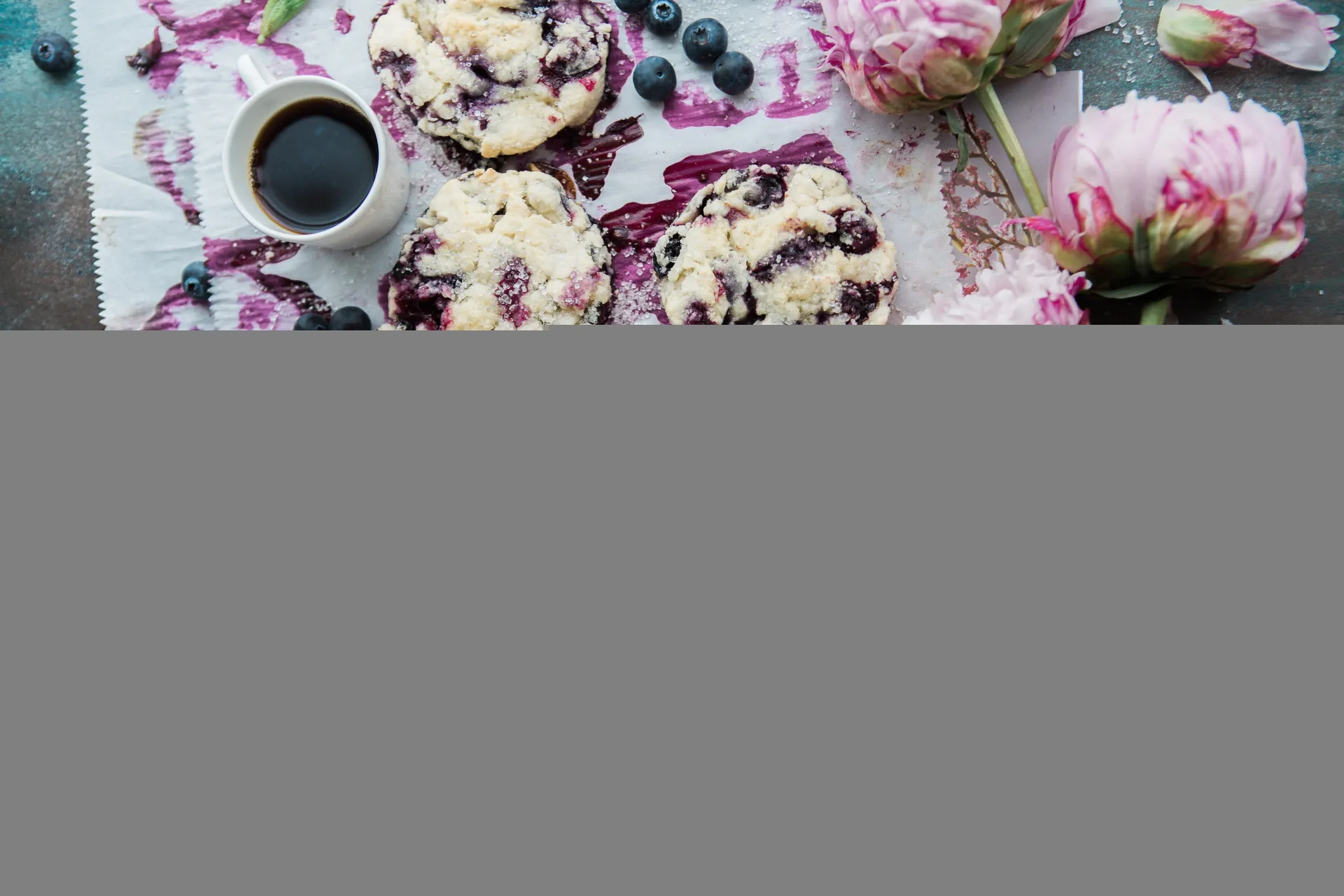Scones recém-assados com blueberries, servidos em uma tábua de madeira.