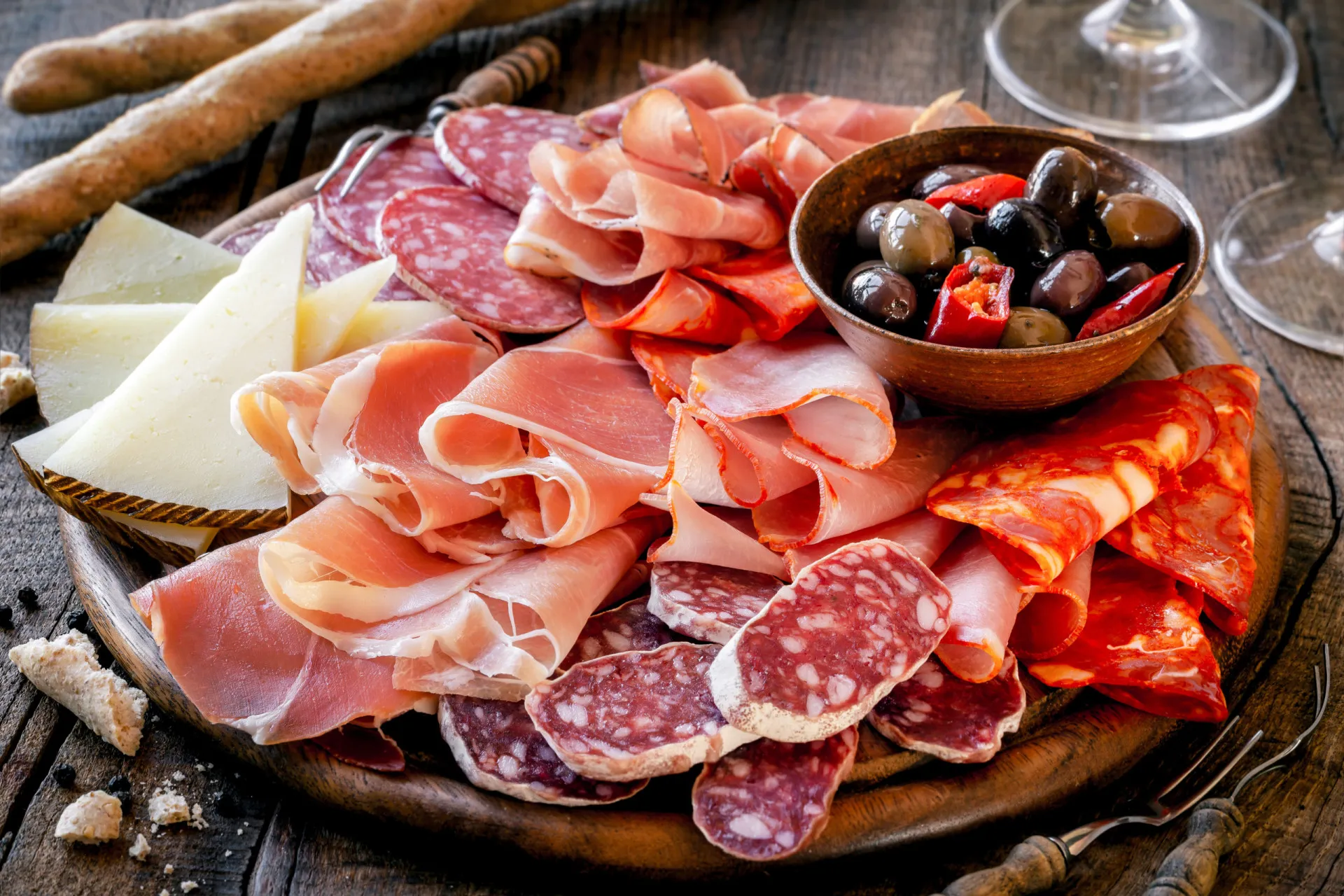 Uma variedade de carnes curadas e processadas, como salame, presunto e salsichas.