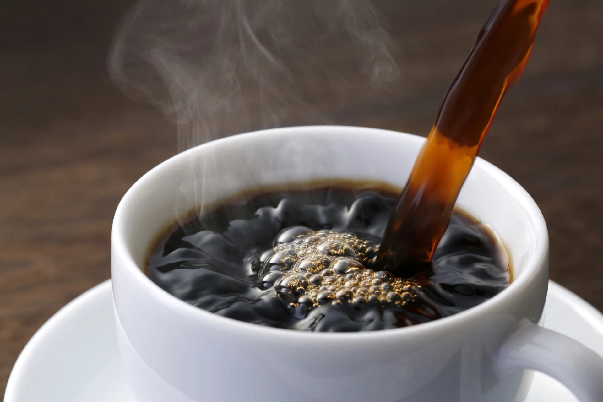 Uma xícara de café quente com grãos de café espalhados ao redor.