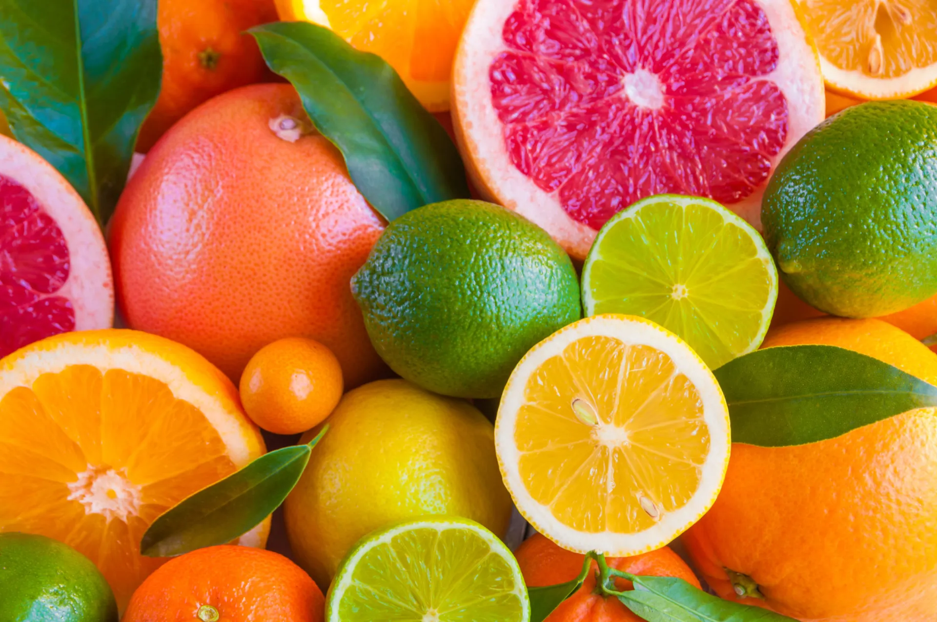 Uma variedade de frutas cítricas, como laranjas, limões e toranjas, cortadas ao meio.