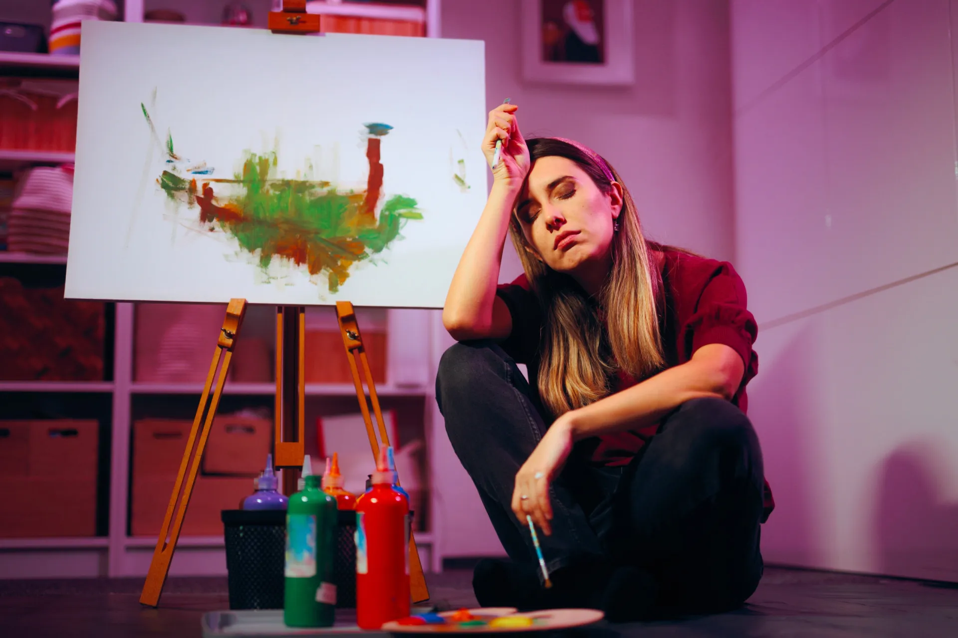 Pessoa sentada em uma escrivaninha, desistindo de um projeto pela metade.