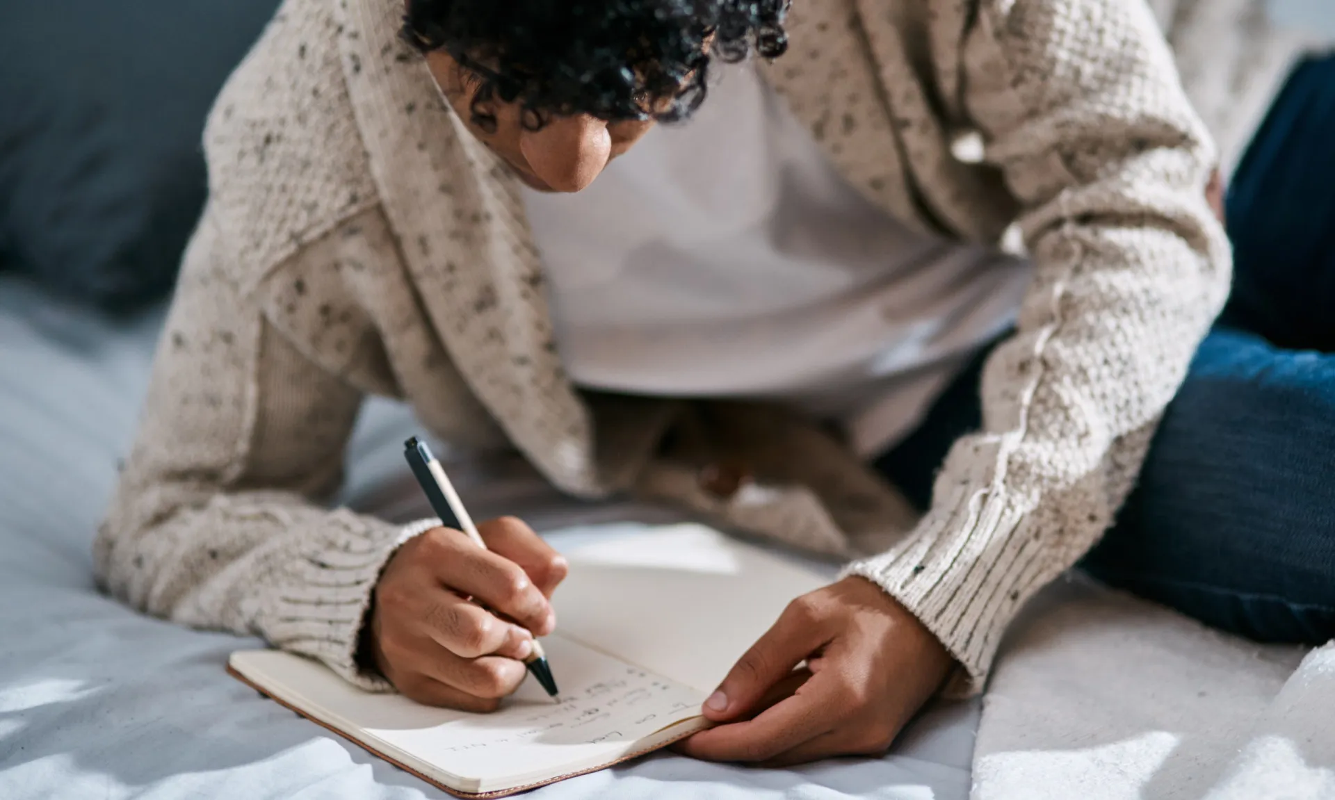 Mãos escrevendo em um diário, registrando pensamentos e emoções para autoconhecimento.