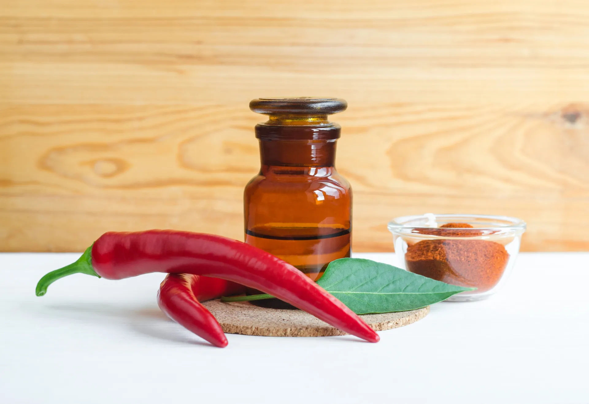 Cápsulas de capsaicina e um chá de pimenta caiena, mostrando as formas de consumo.