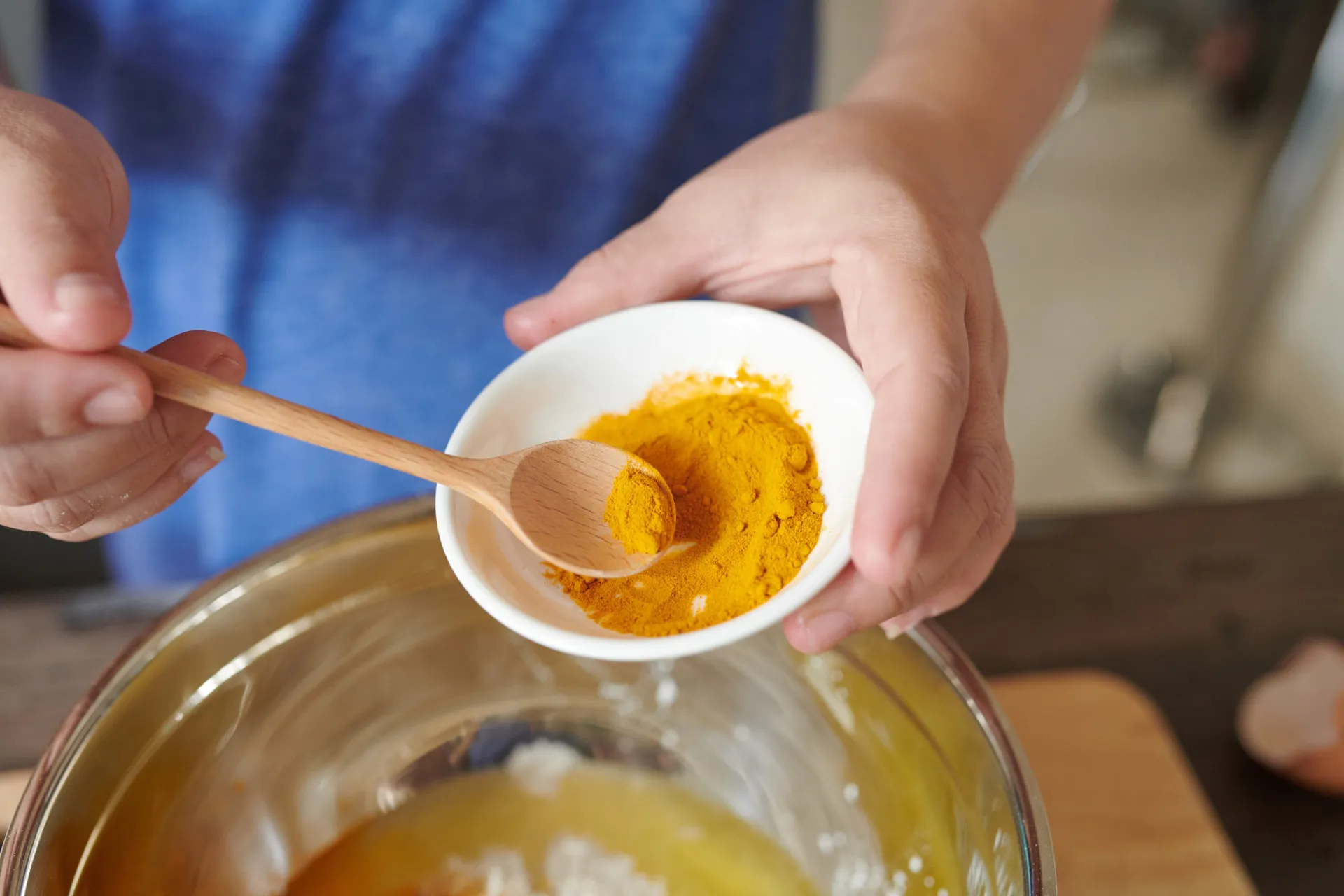 Pó de cúrcuma de cor laranja vibrante e raízes frescas ao lado, destacando sua origem natural.