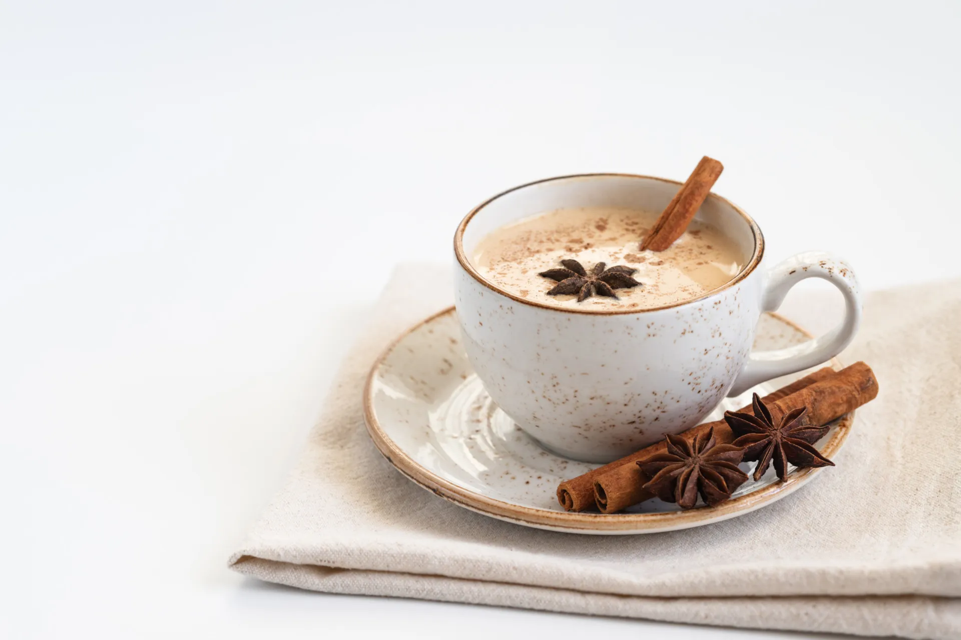 Ingredientes do masala chai, como cravo, cardamomo e canela, dispostos de forma artística.