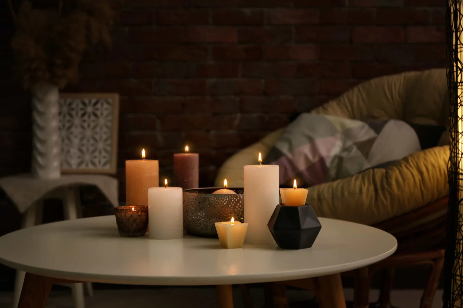 Grupo de velas de diferentes tamanhos acesas sobre uma mesa de centro de madeira.