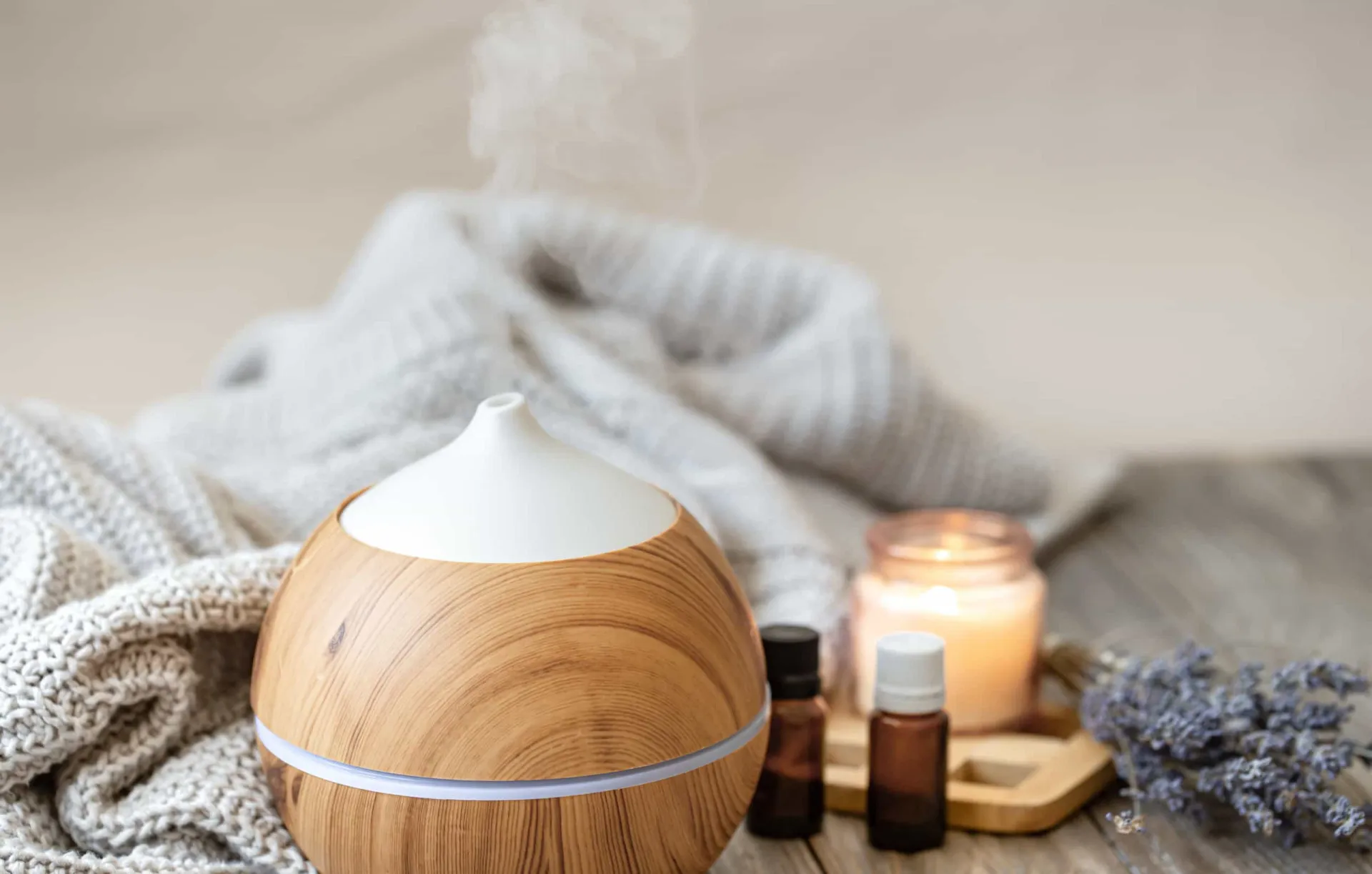 Difusor de óleos essenciais liberando vapor em uma sala aconchegante.