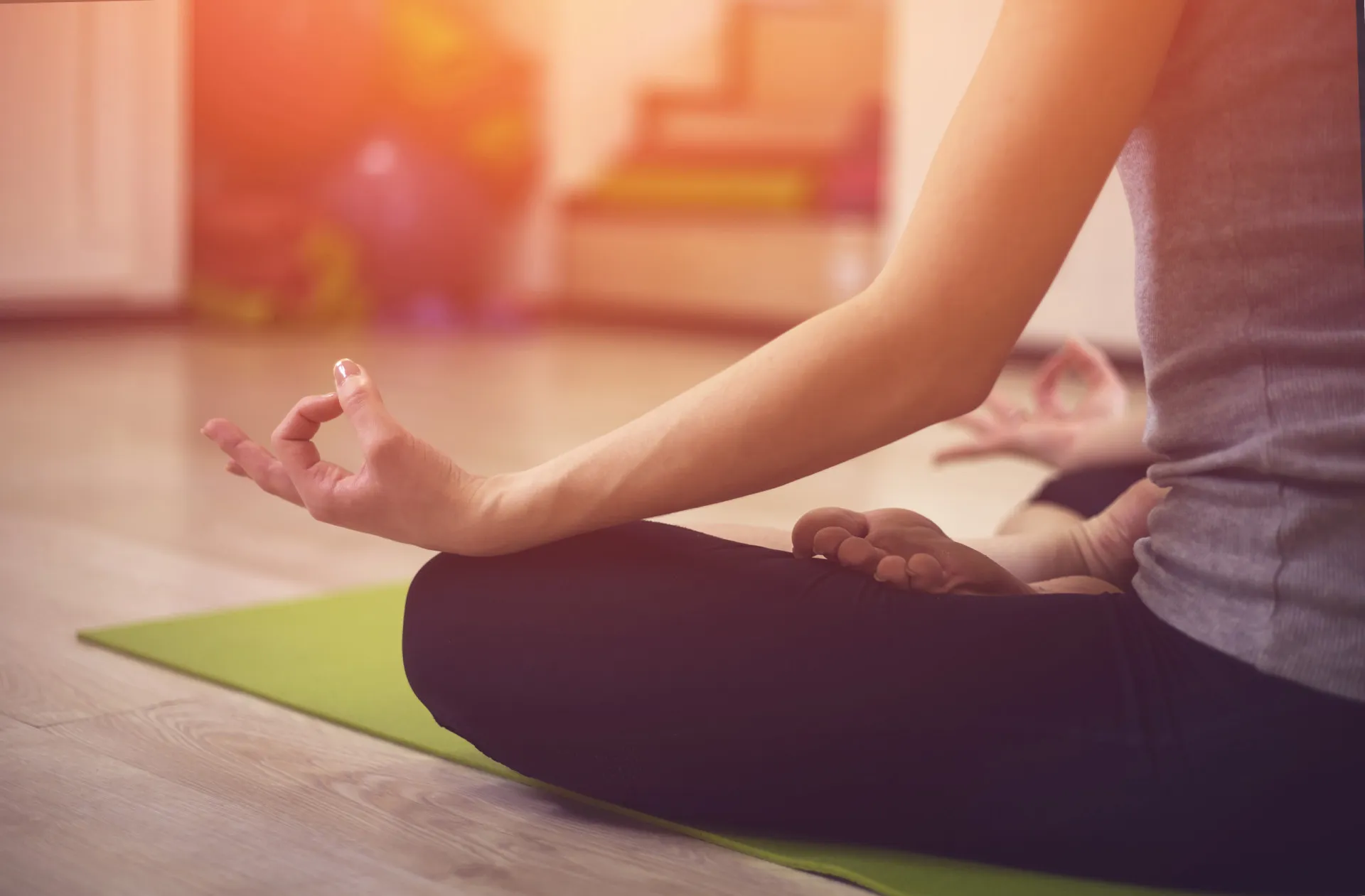 Mulher praticando uma postura de yoga em um ambiente calmo e iluminado por velas.