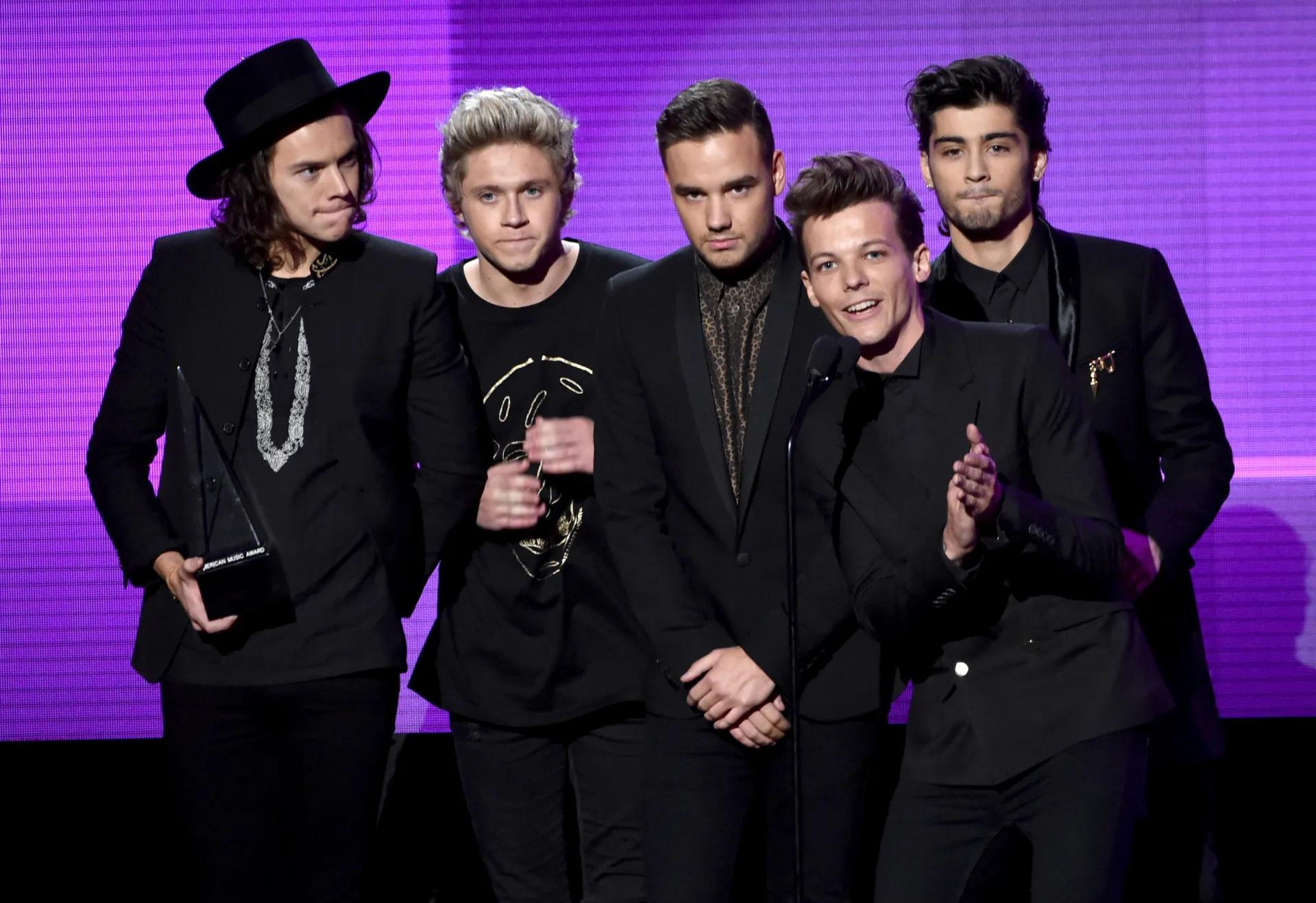 Zayn Malik e os outros quatro membros do One Direction juntos no palco.