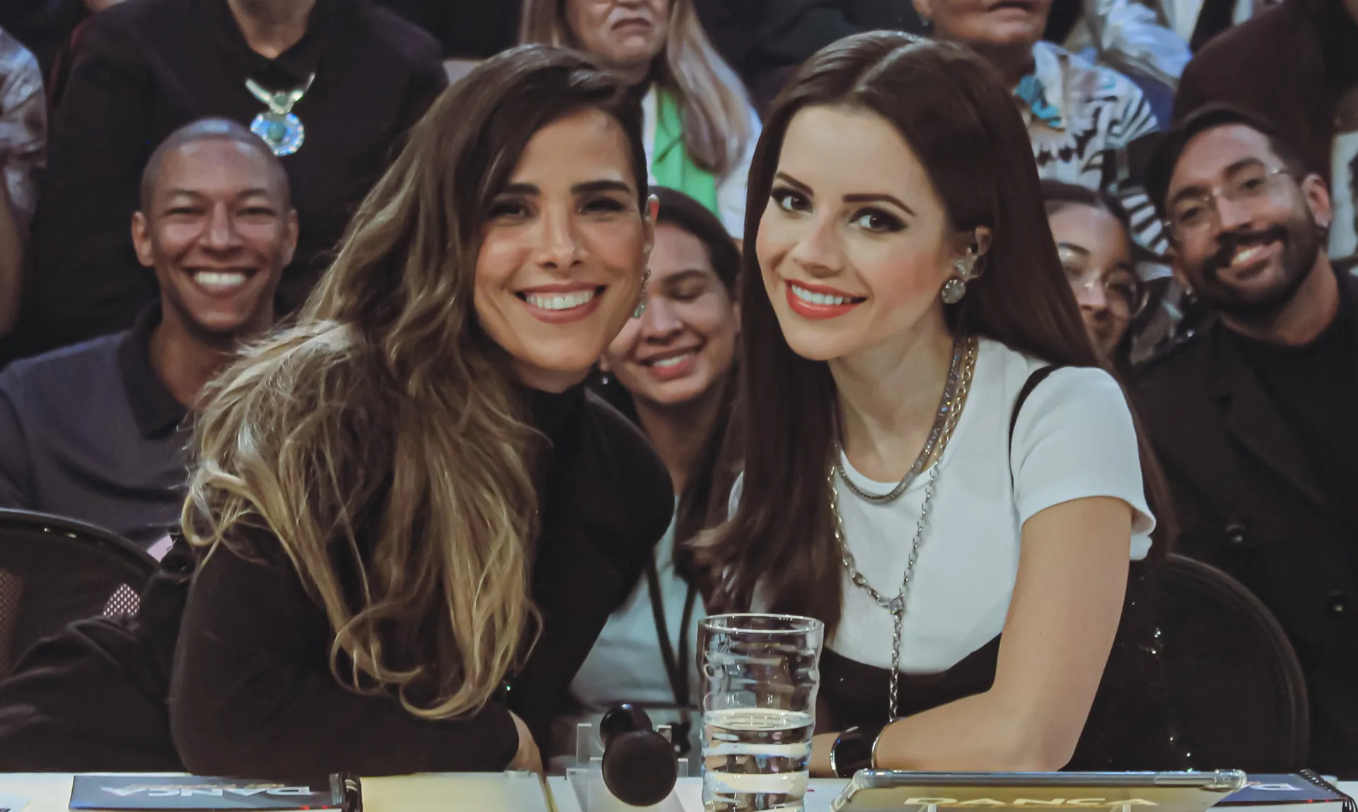 Wanessa Camargo e Sandy se abraçando emocionadas no palco do programa 'Domingão'.