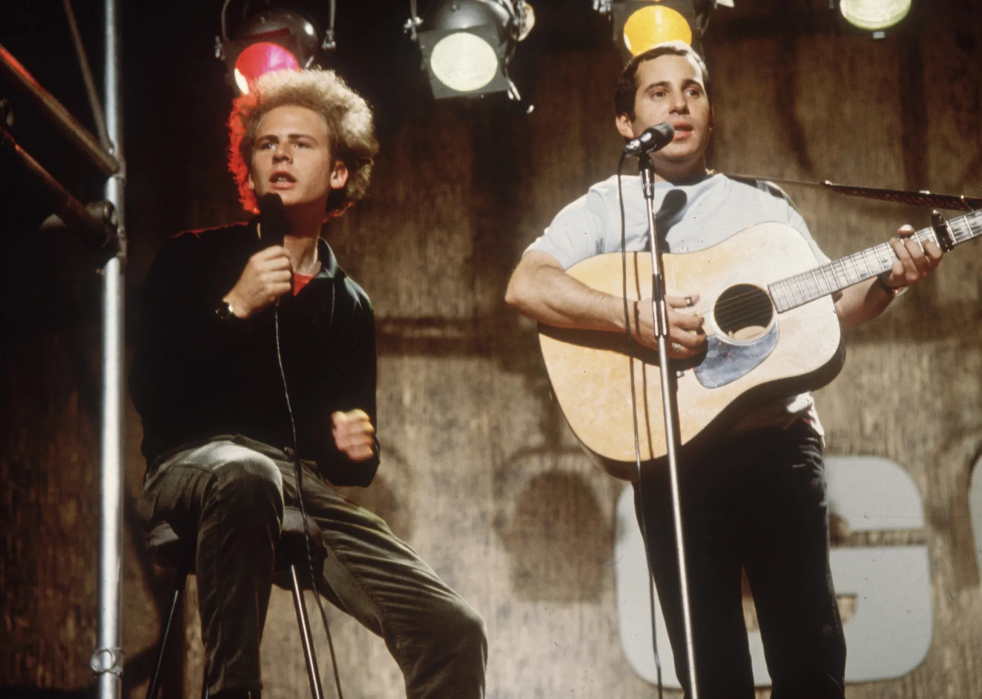 Paul Simon e Art Garfunkel se apresentando juntos durante o auge da dupla.