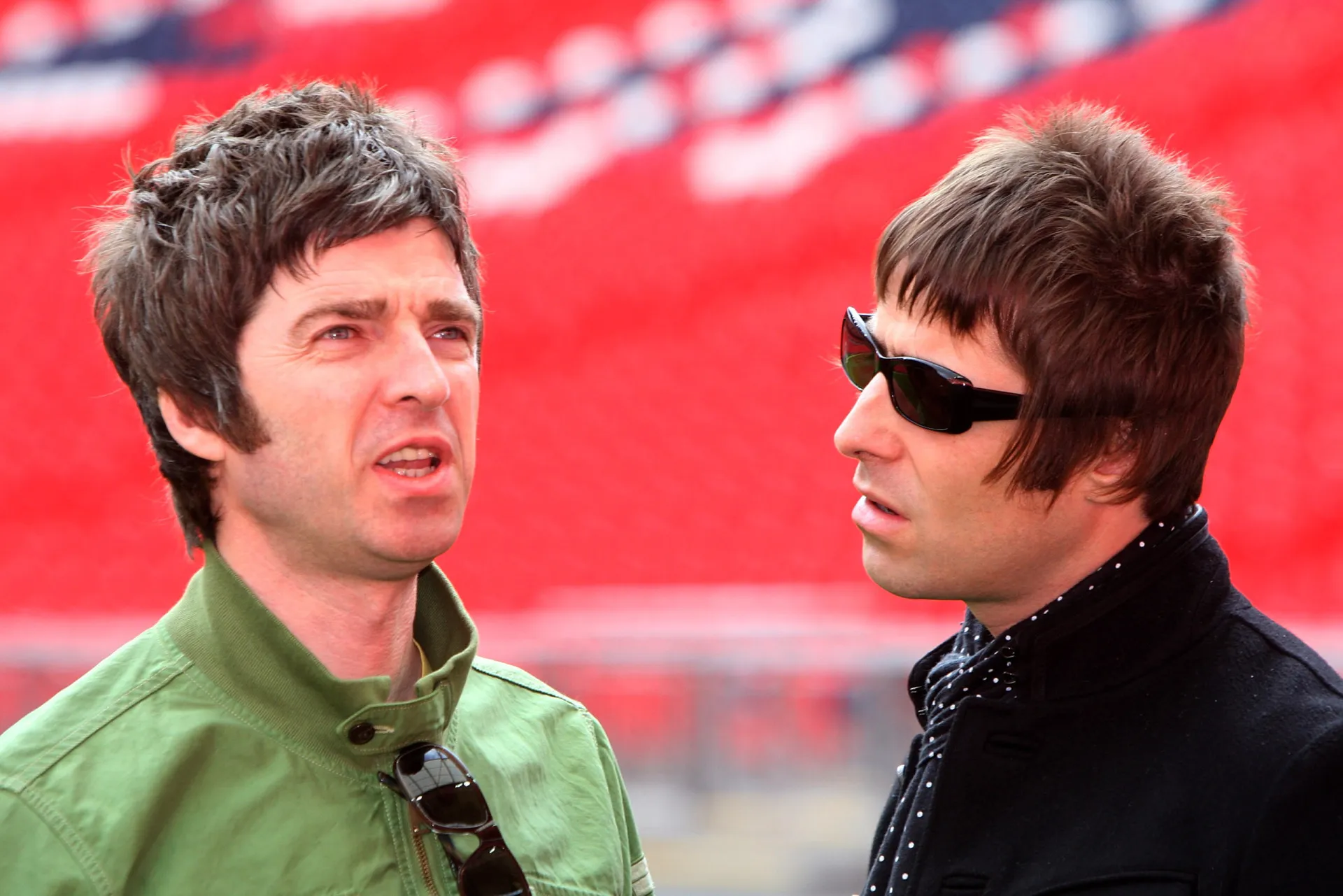 Os irmãos Noel e Liam Gallagher, do Oasis, se encarando no palco.