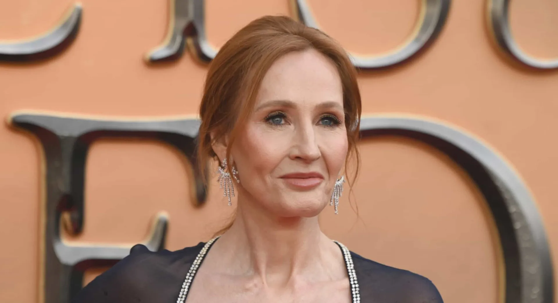 A autora J. K. Rowling posando para uma foto em um evento de gala.