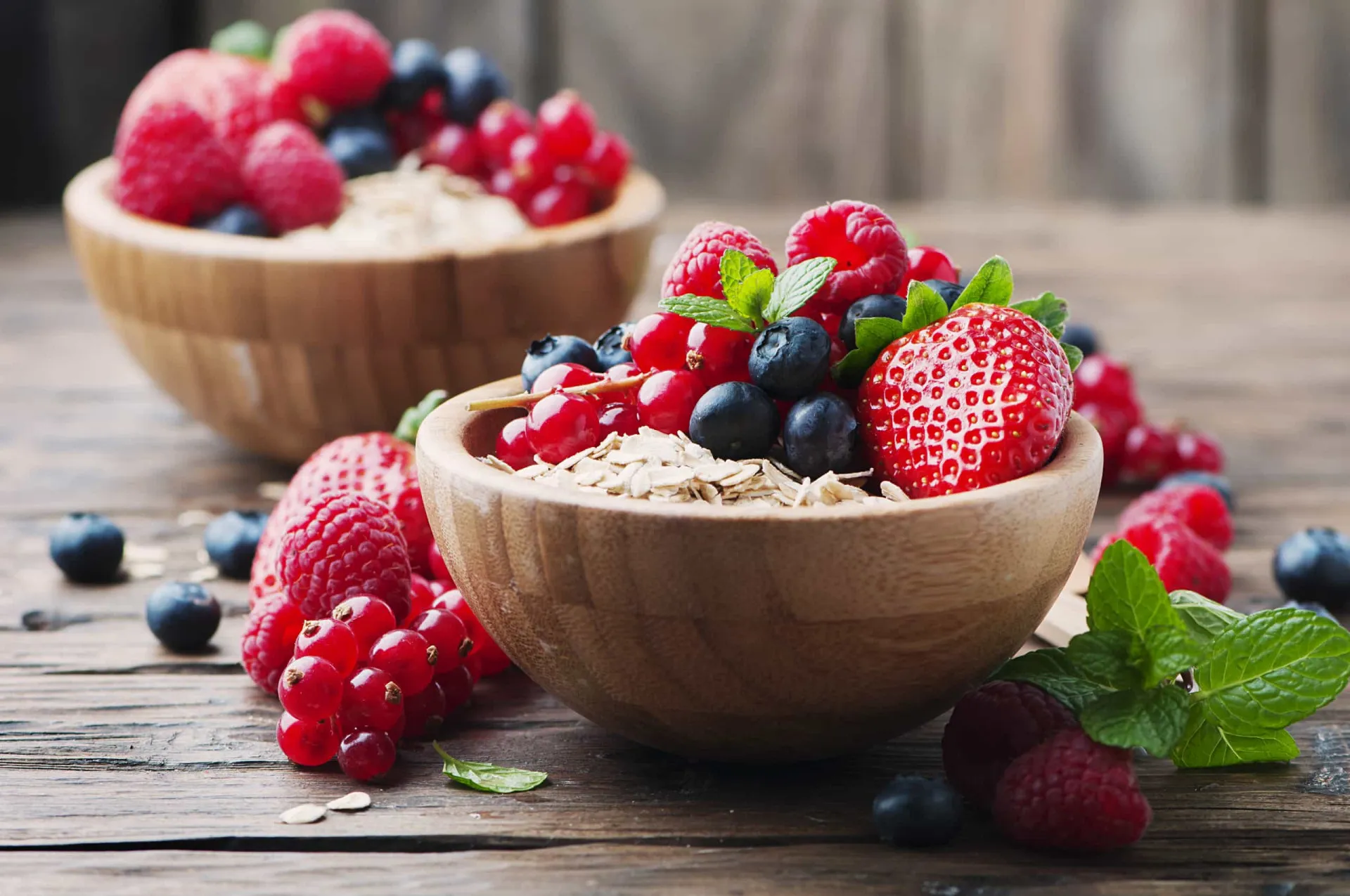 Uma tigela de cereal integral com um mix colorido de frutas silvestres e leite.