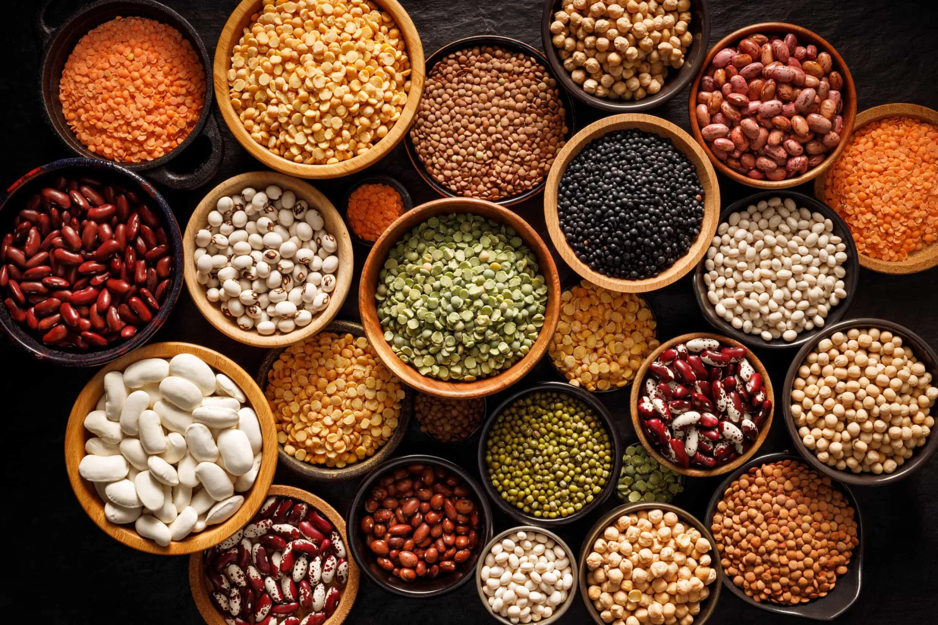 Um mix de leguminosas secas, incluindo feijão, lentilha, ervilha e grão-de-bico.