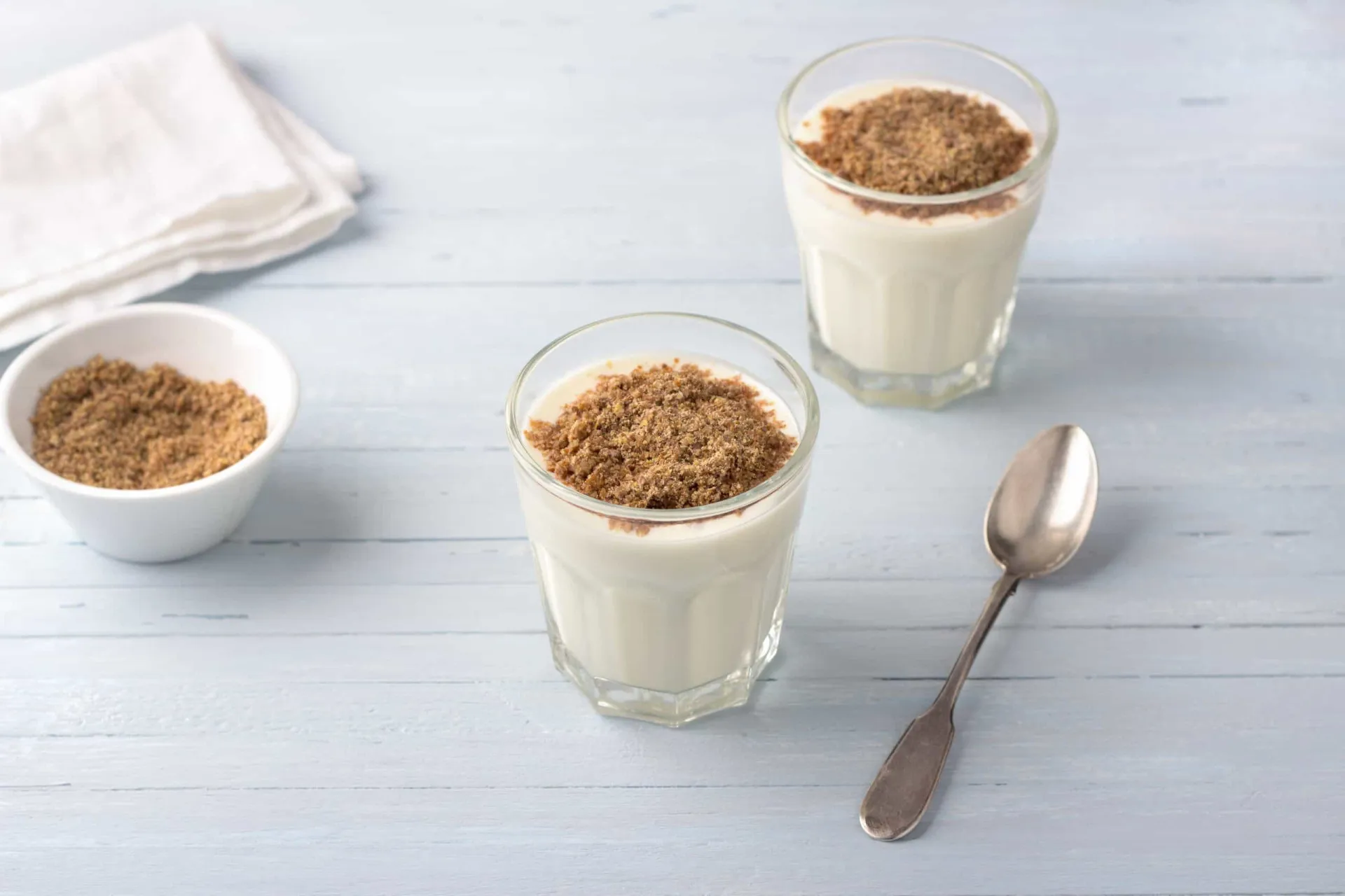 Iogurte natural em uma tigela coberto com sementes de linhaça moída.