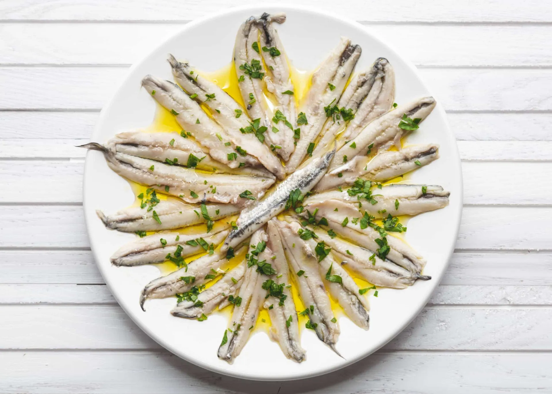 Anchovas frescas em uma tigela de cerâmica, mostrando sua aparência antes do preparo.