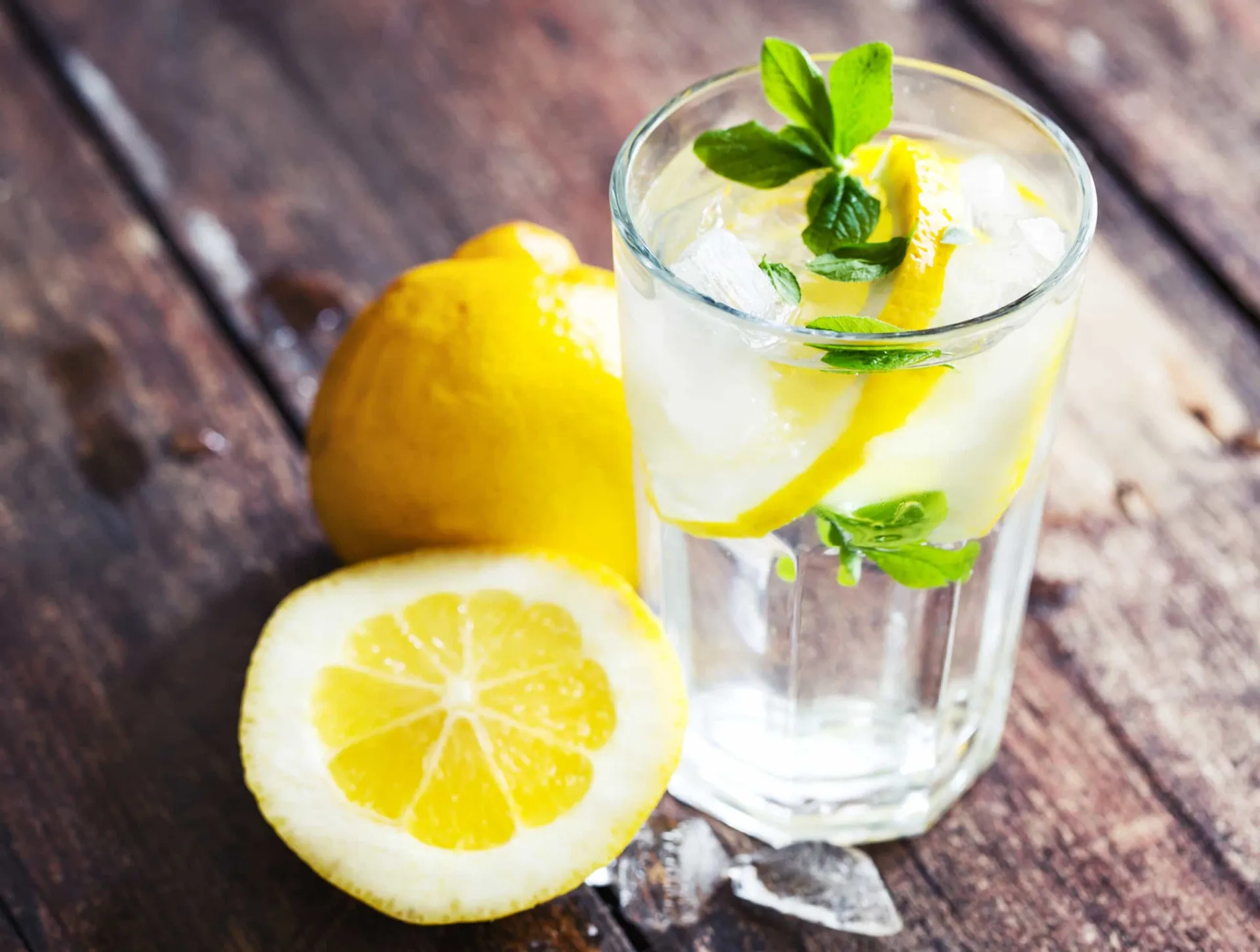 Um copo de água com rodelas de limão, uma bebida refrescante e saudável.