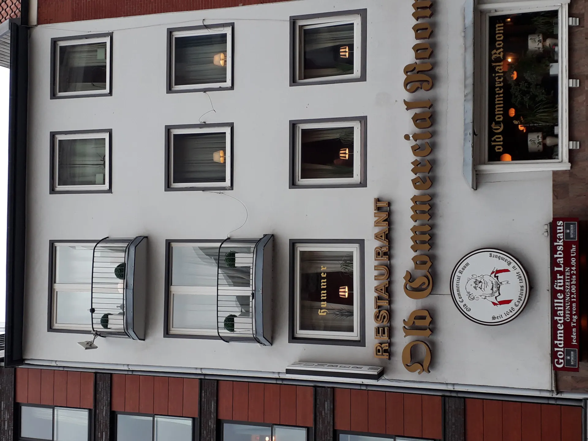Fachada do Old Commercial Room em Hamburgo, um prédio histórico com letreiros clássicos.