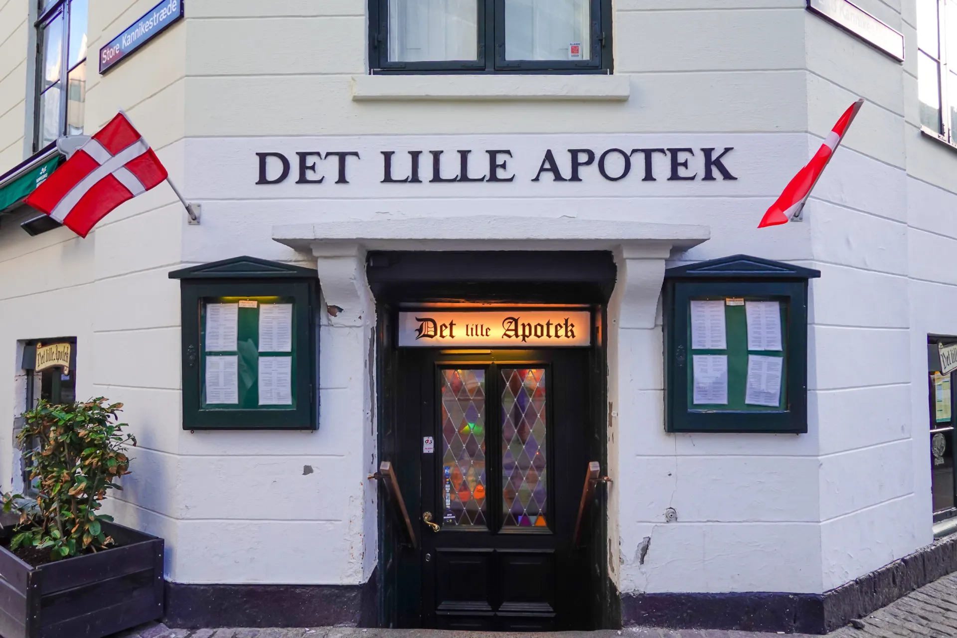 O charmoso interior do Det Lille Apotek em Copenhague, com decoração antiga e ambiente intimista.