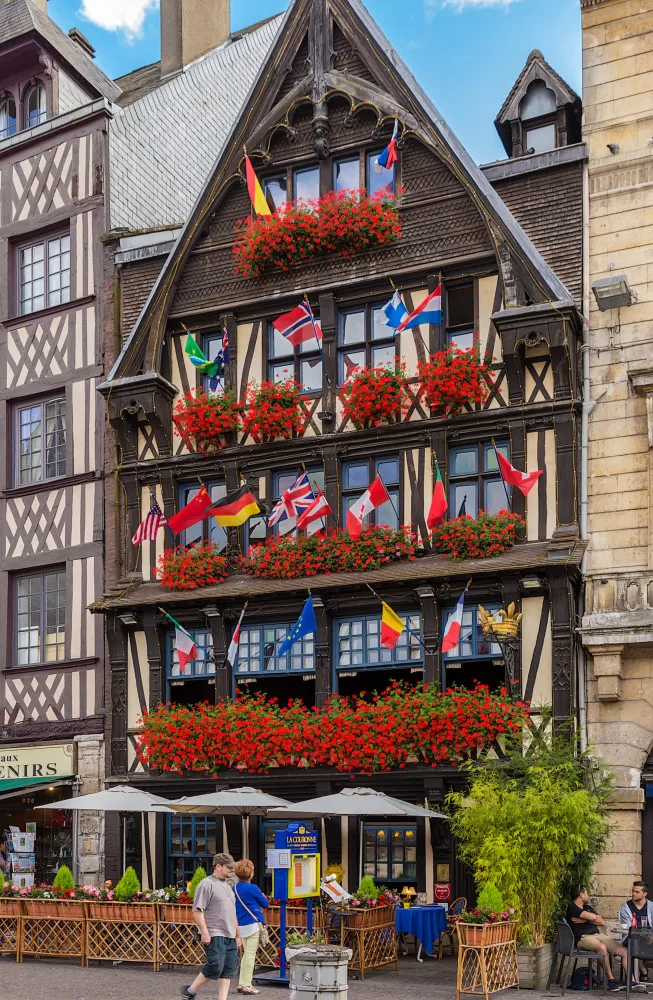 A charmosa fachada de enxaimel do restaurante La Couronne, na histórica praça de Rouen, França.