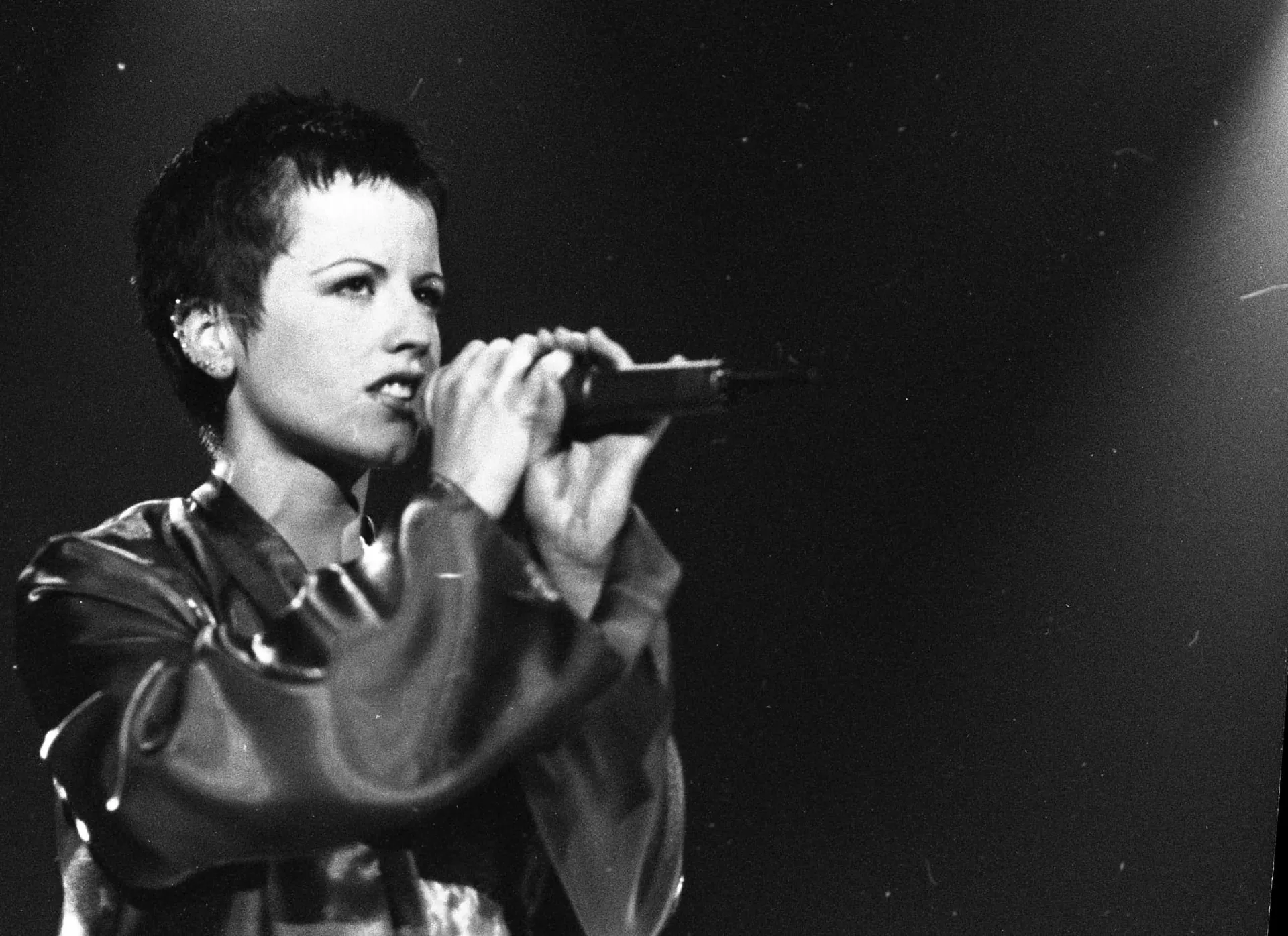 Dolores O'Riordan, vocalista da banda The Cranberries, cantando no palco.