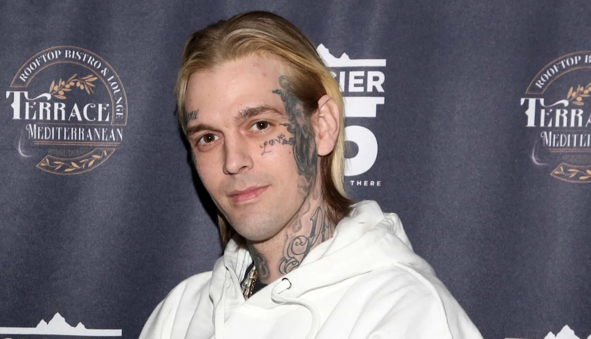 O cantor Aaron Carter se apresentando em um show, microfone na mão.
