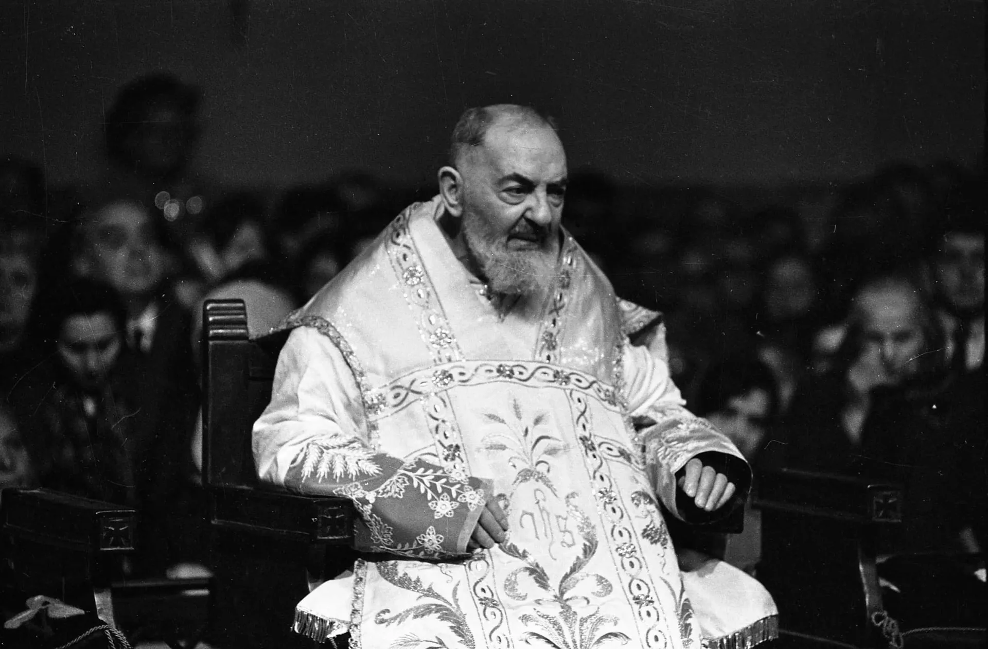 Padre Pio em um momento de oração, demonstrando sua profunda devoção e concentração.
