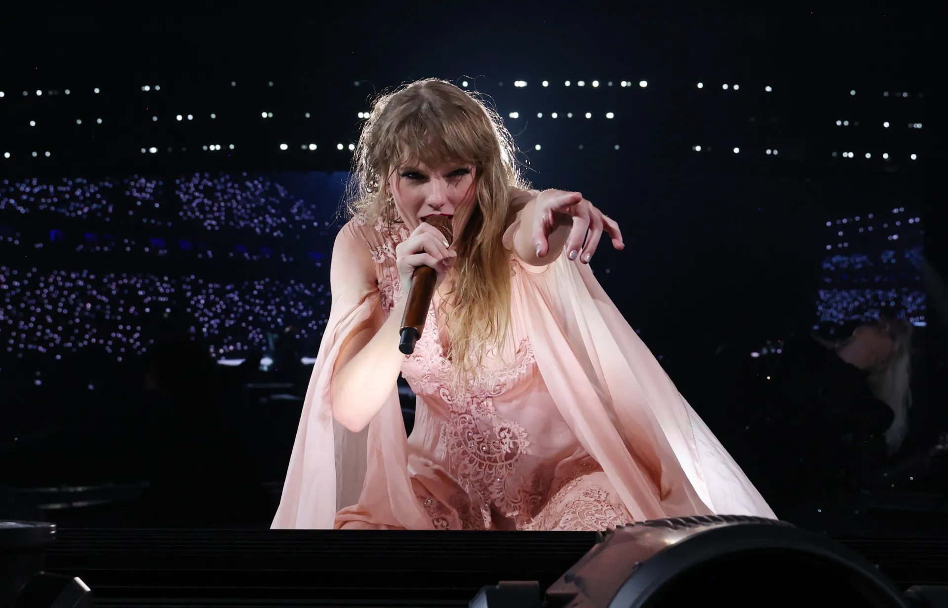 Taylor Swift se apresentando no palco durante um show, um ícone da cultura pop americana.