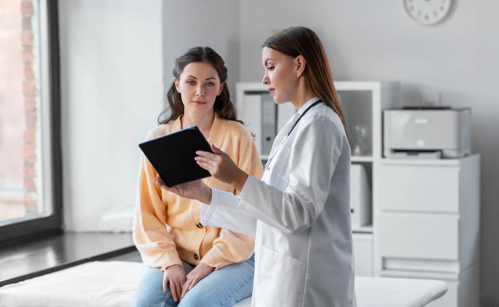 Médico conversando com um paciente, com uma calculadora e dinheiro sobre a mesa, representando os altos custos da saúde.