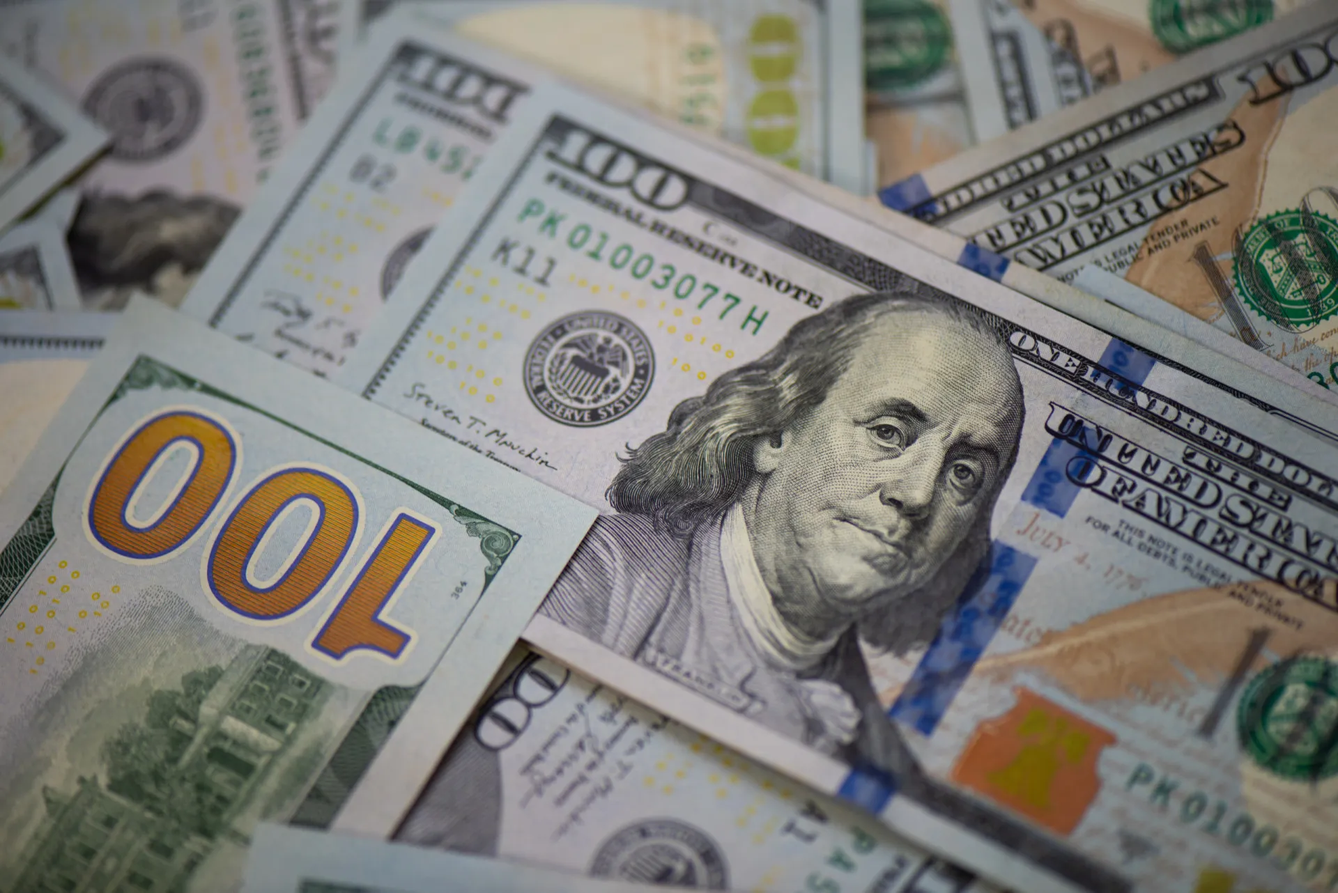 Notas de dólar americano empilhadas, simbolizando a força da moeda.
