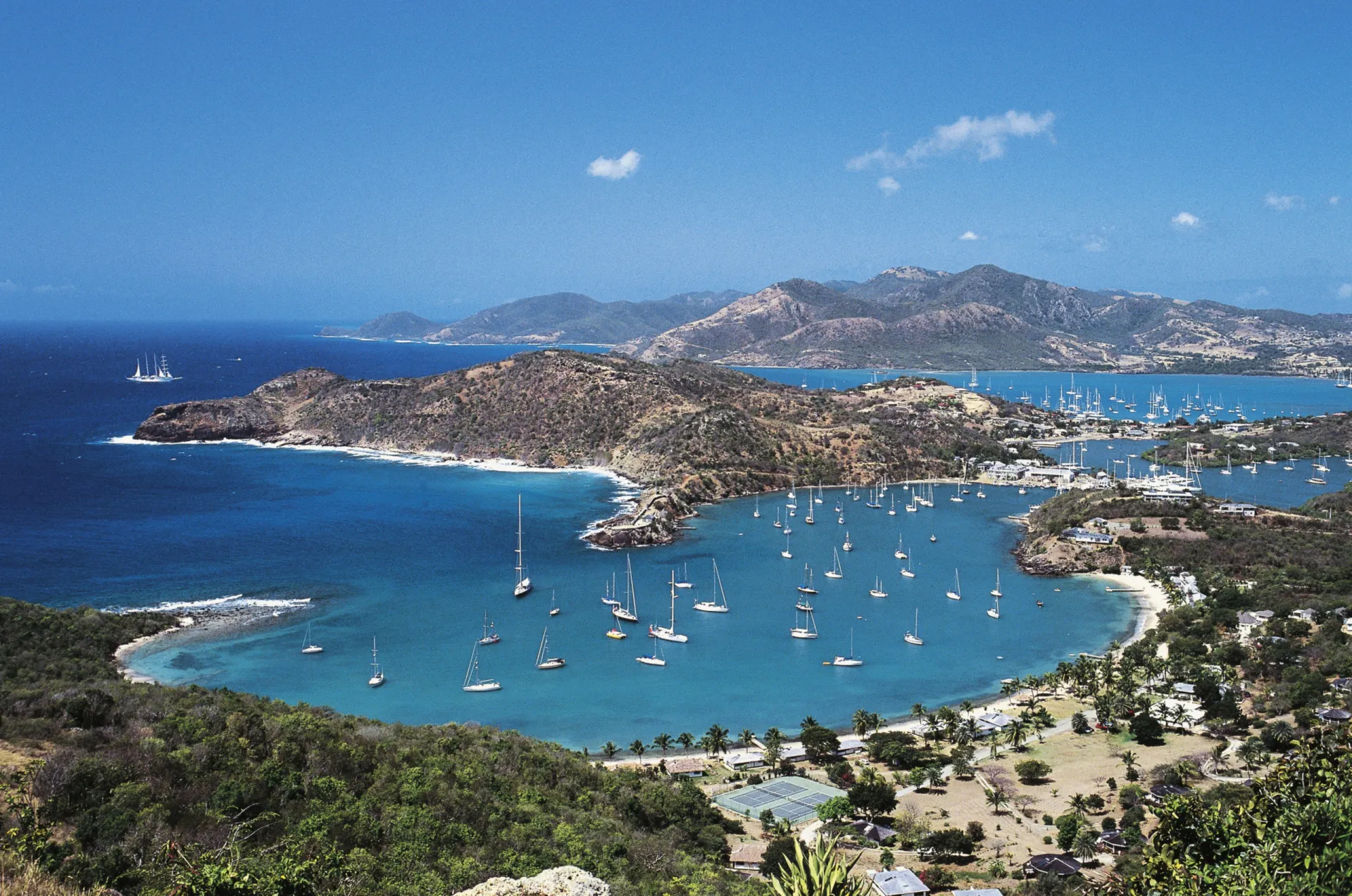 Vista da ilha caribenha de Montserrat, com a vegetação exuberante e o vulcão ao fundo.