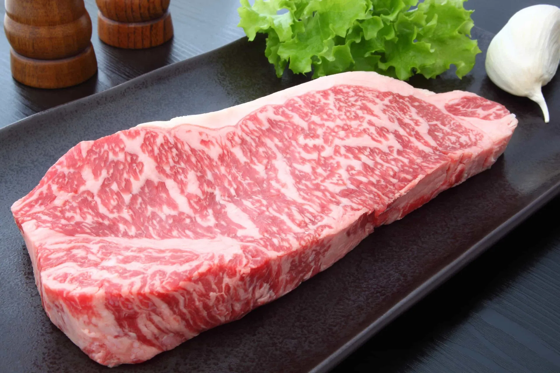 Fatias finas de carne Wagyu crua, exibindo seu marmoreio característico.