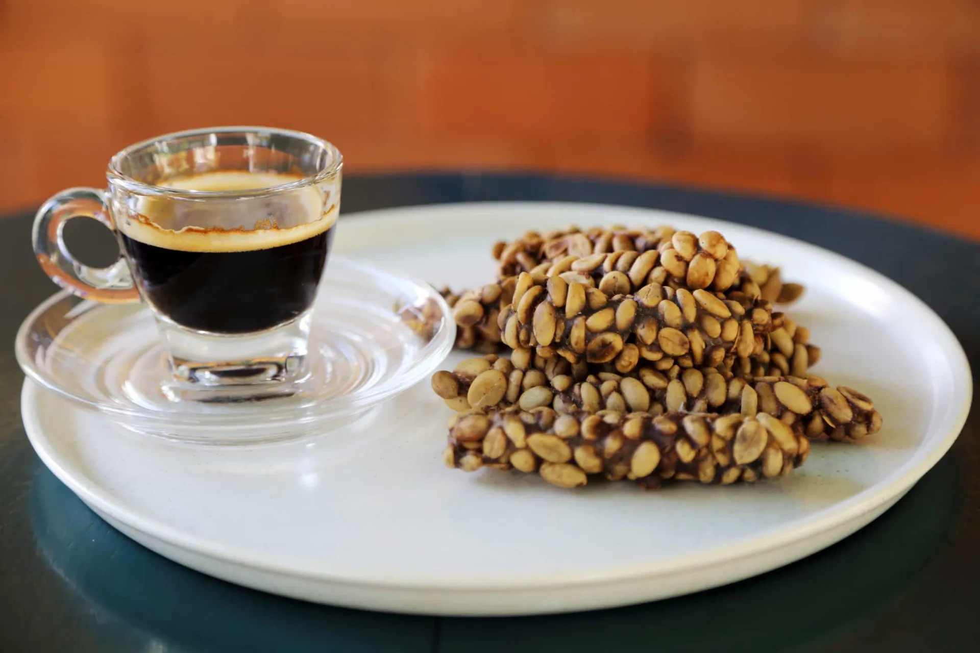 Grãos de café Kopi Luwak ao lado de um civeta, o animal responsável pelo seu processo único.