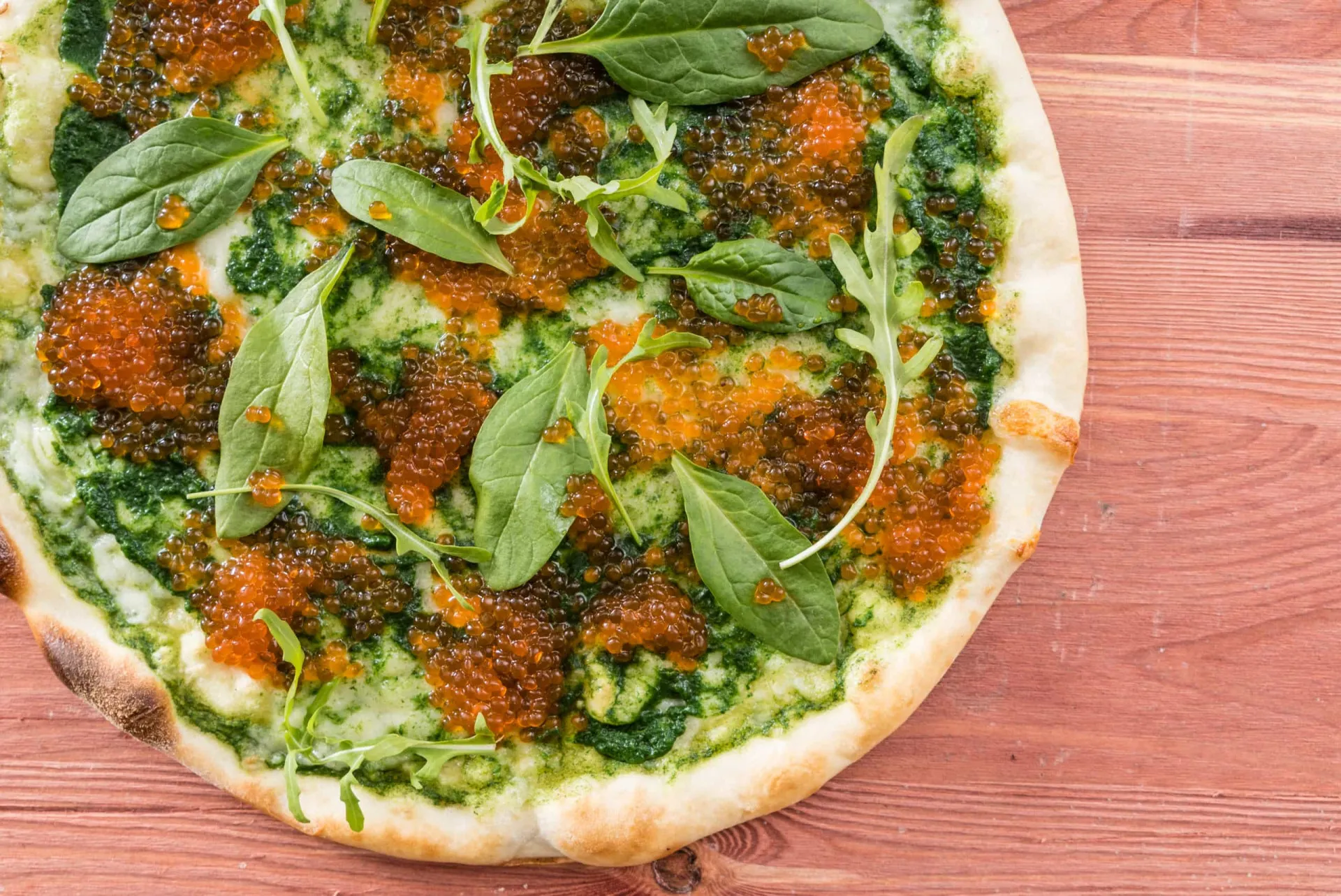 Uma pizza luxuosa coberta com ingredientes como lagosta, caviar e flocos de ouro.