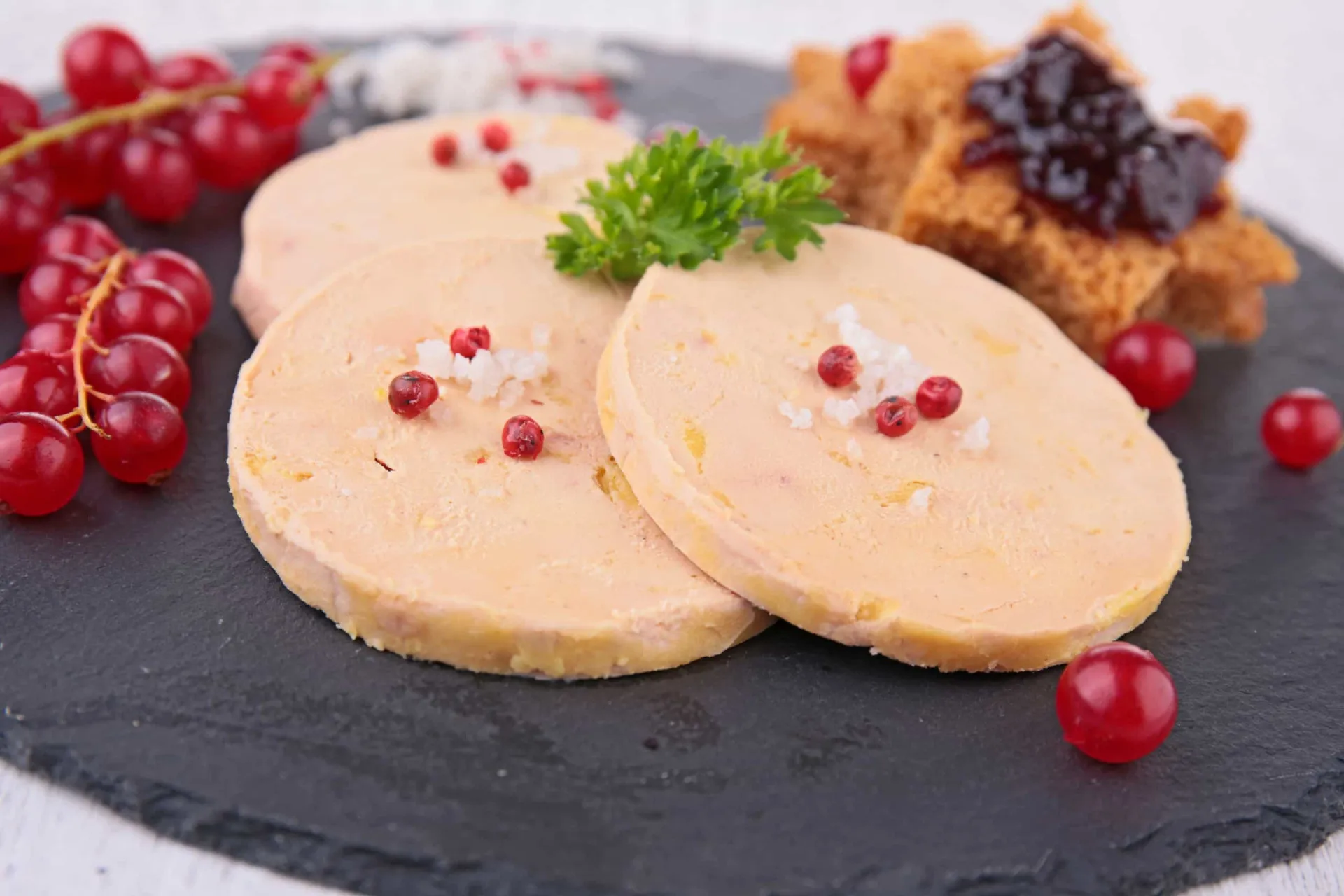 Uma porção de foie gras servida em um prato elegante com geleia.