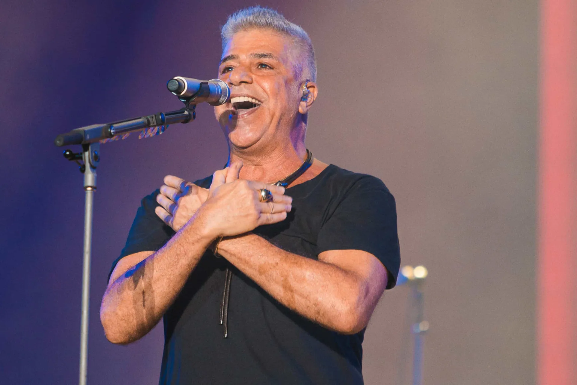 Lulu Santos, o hitmaker do pop rock brasileiro, sorrindo durante um show.